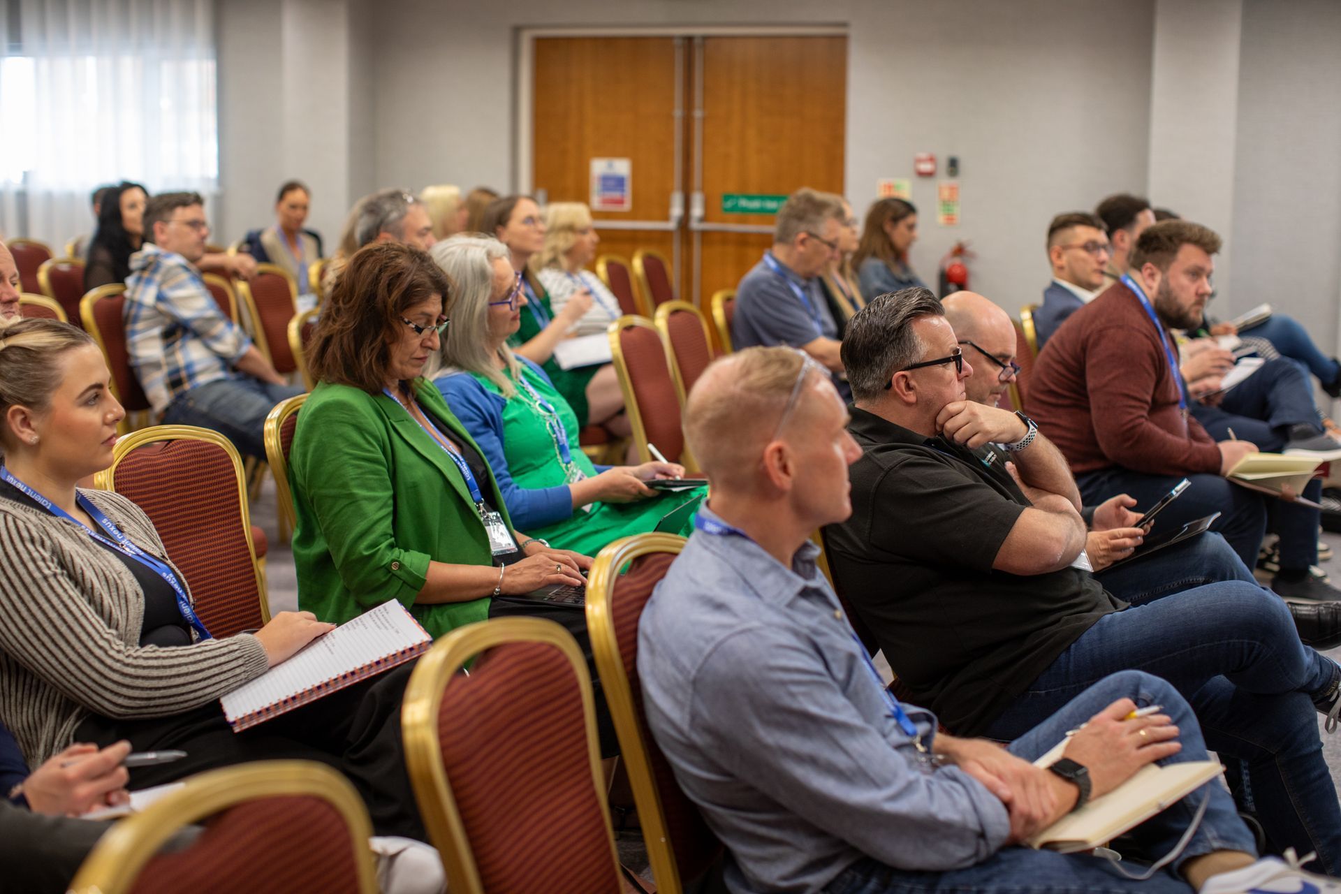 A group of people are sitting in chairs in a conference room.