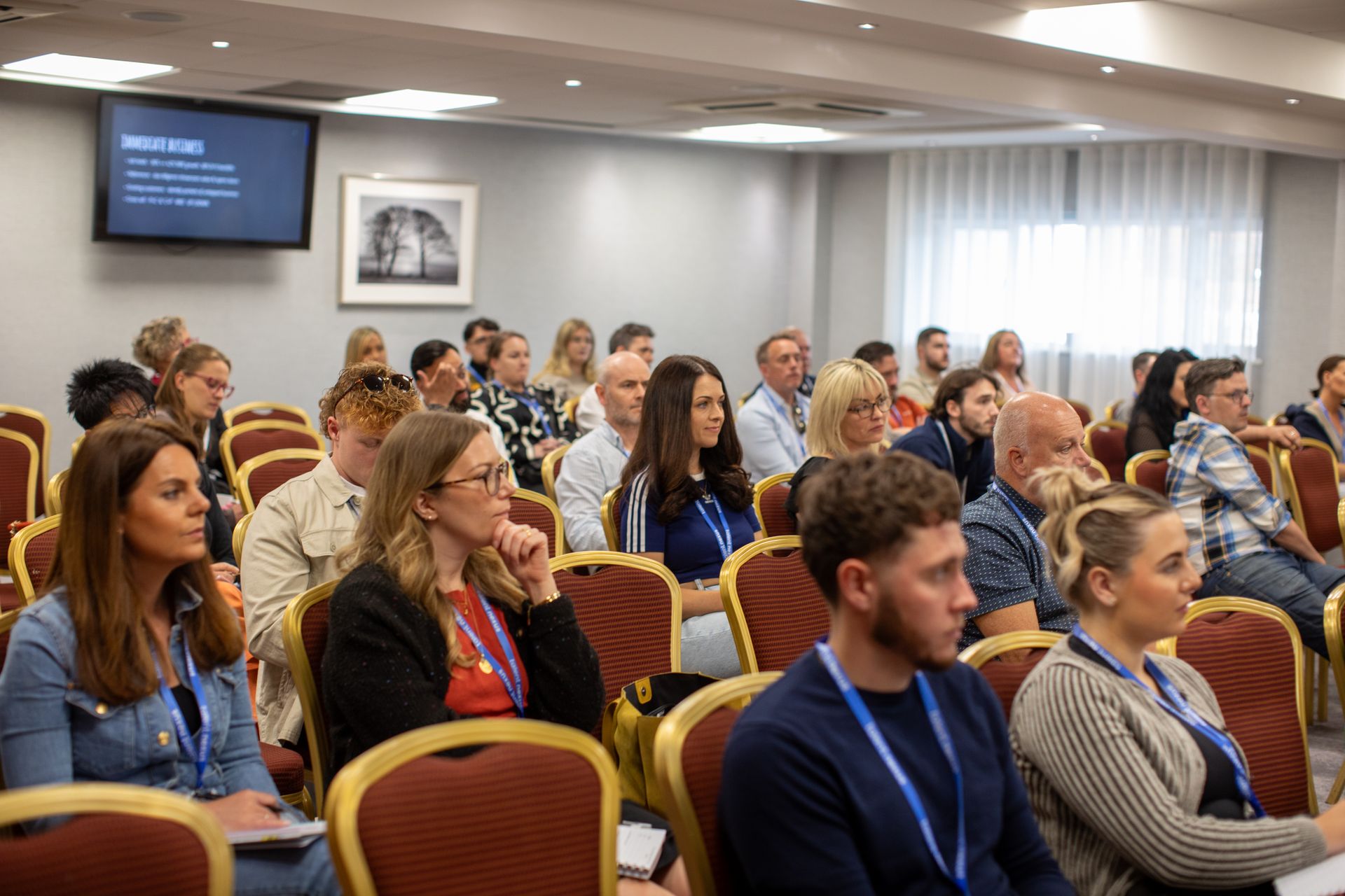 A group of people are sitting in chairs in a conference room.