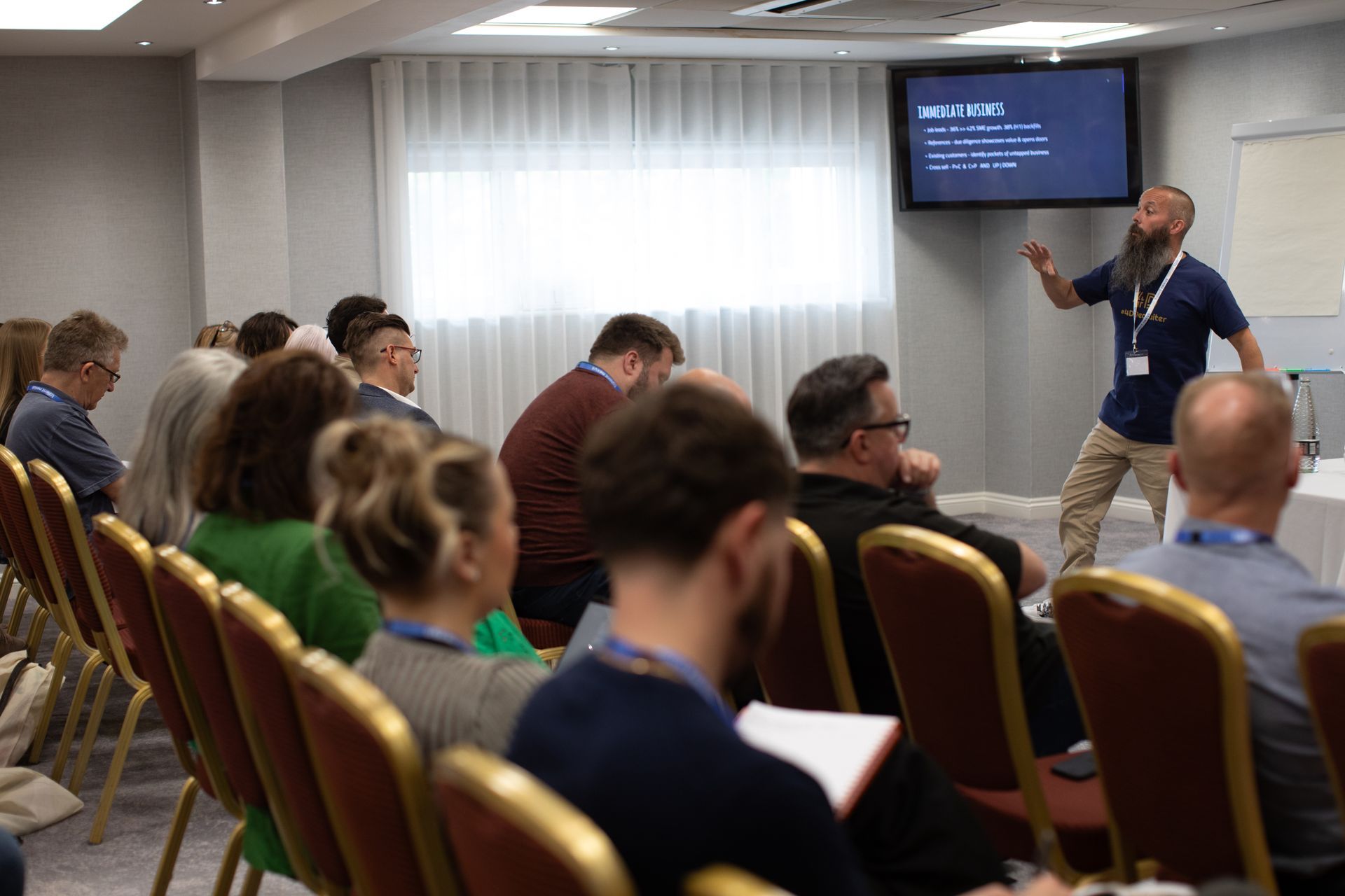 A man is giving a presentation to a group of people in a conference room.