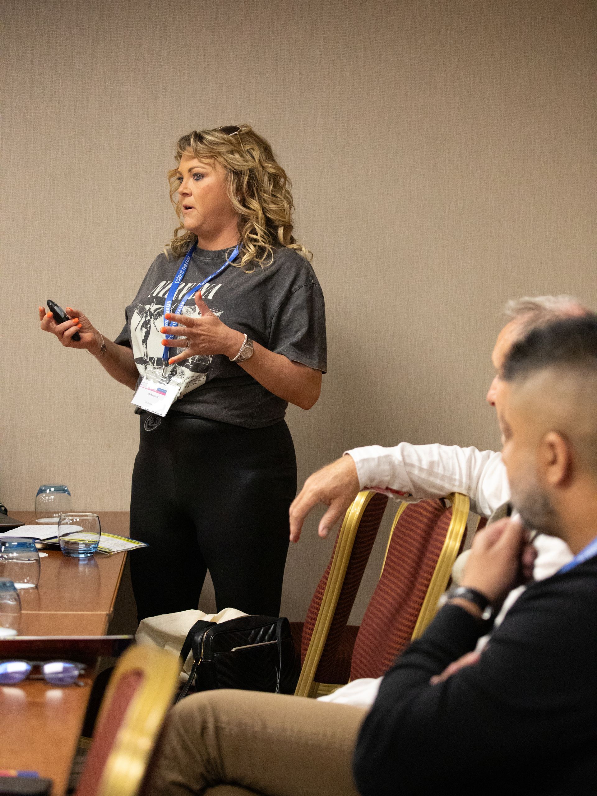 A woman is giving a presentation to a group of people sitting at a table.
