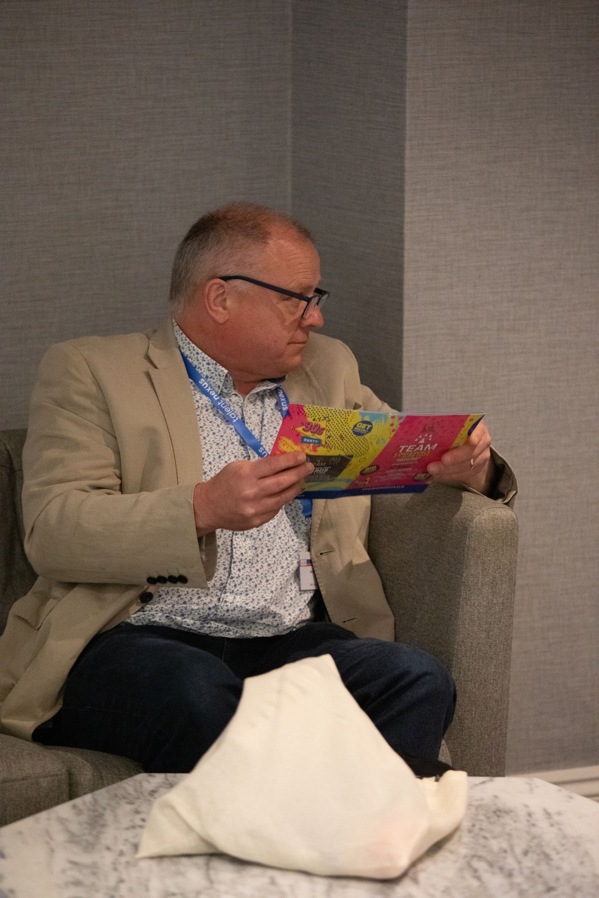 A man is sitting in a chair reading a book.
