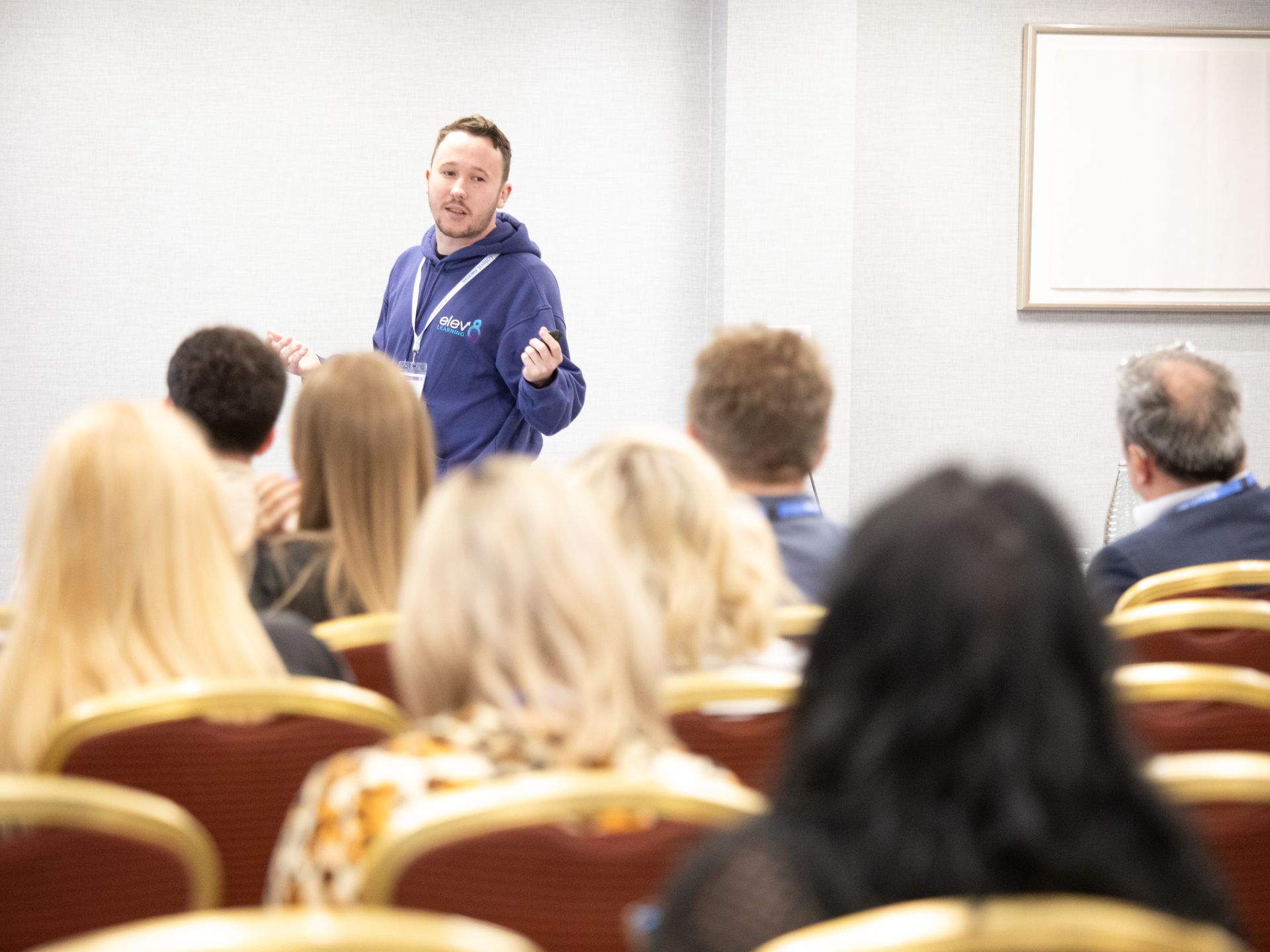 A man is giving a presentation to a group of people in a conference room.