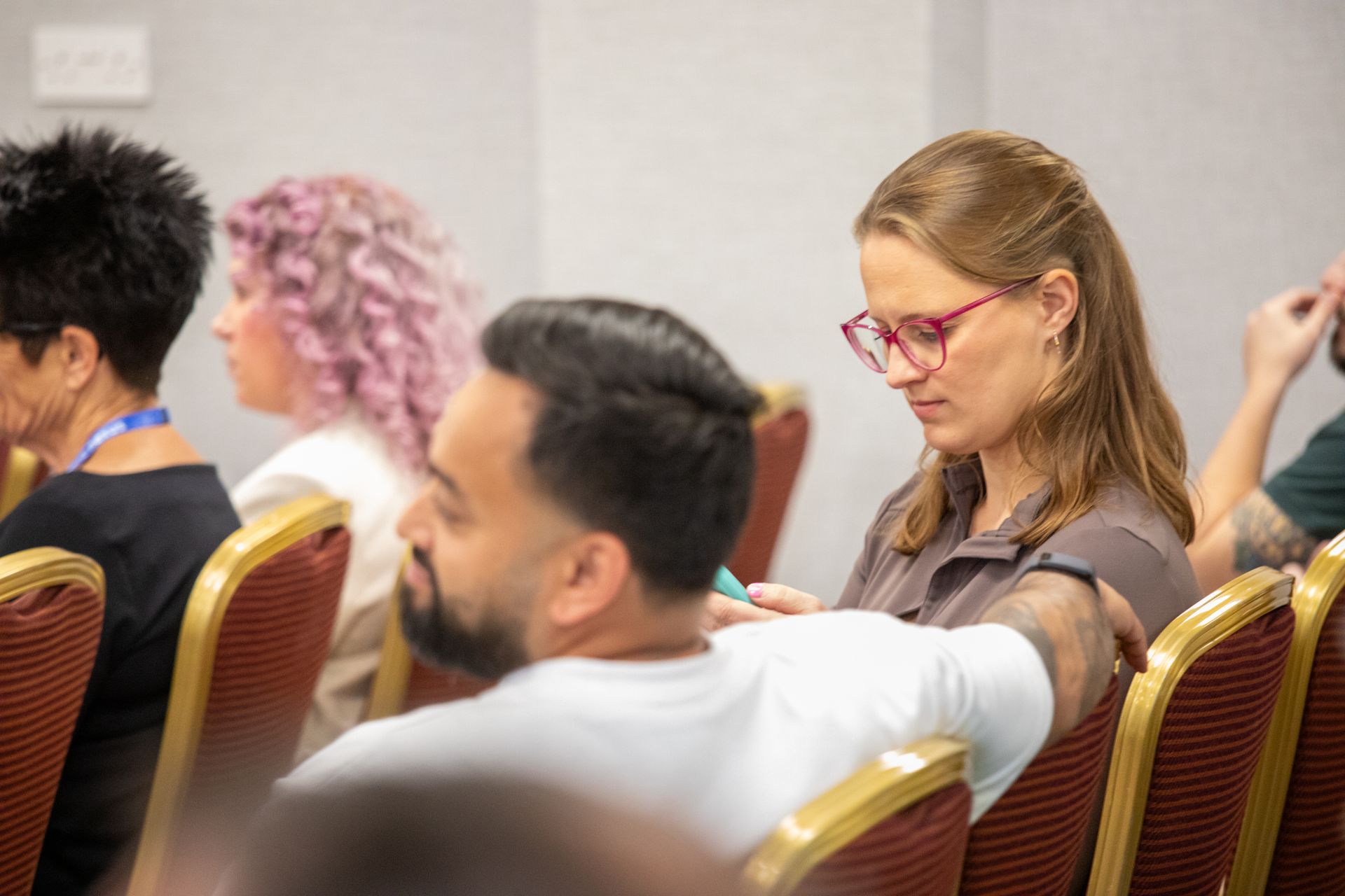 A group of people are sitting in chairs at a conference.