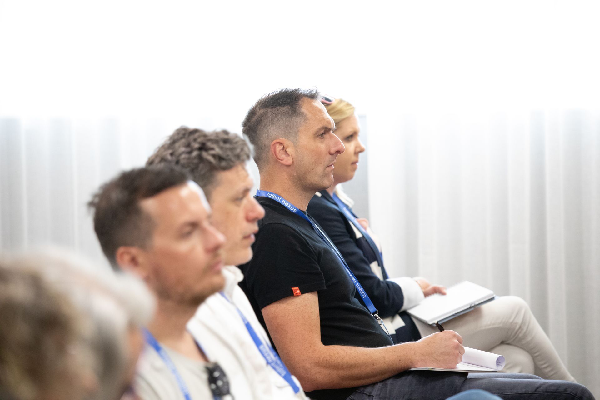 A group of people are sitting in a row in a room.
