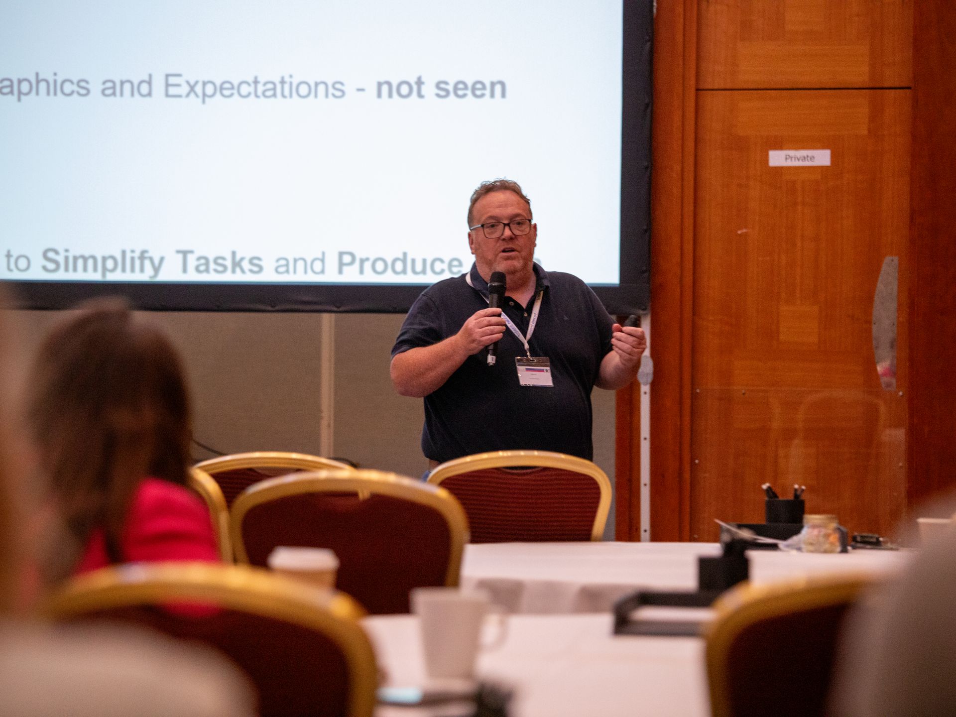 A man is giving a presentation to a group of people in a conference room.