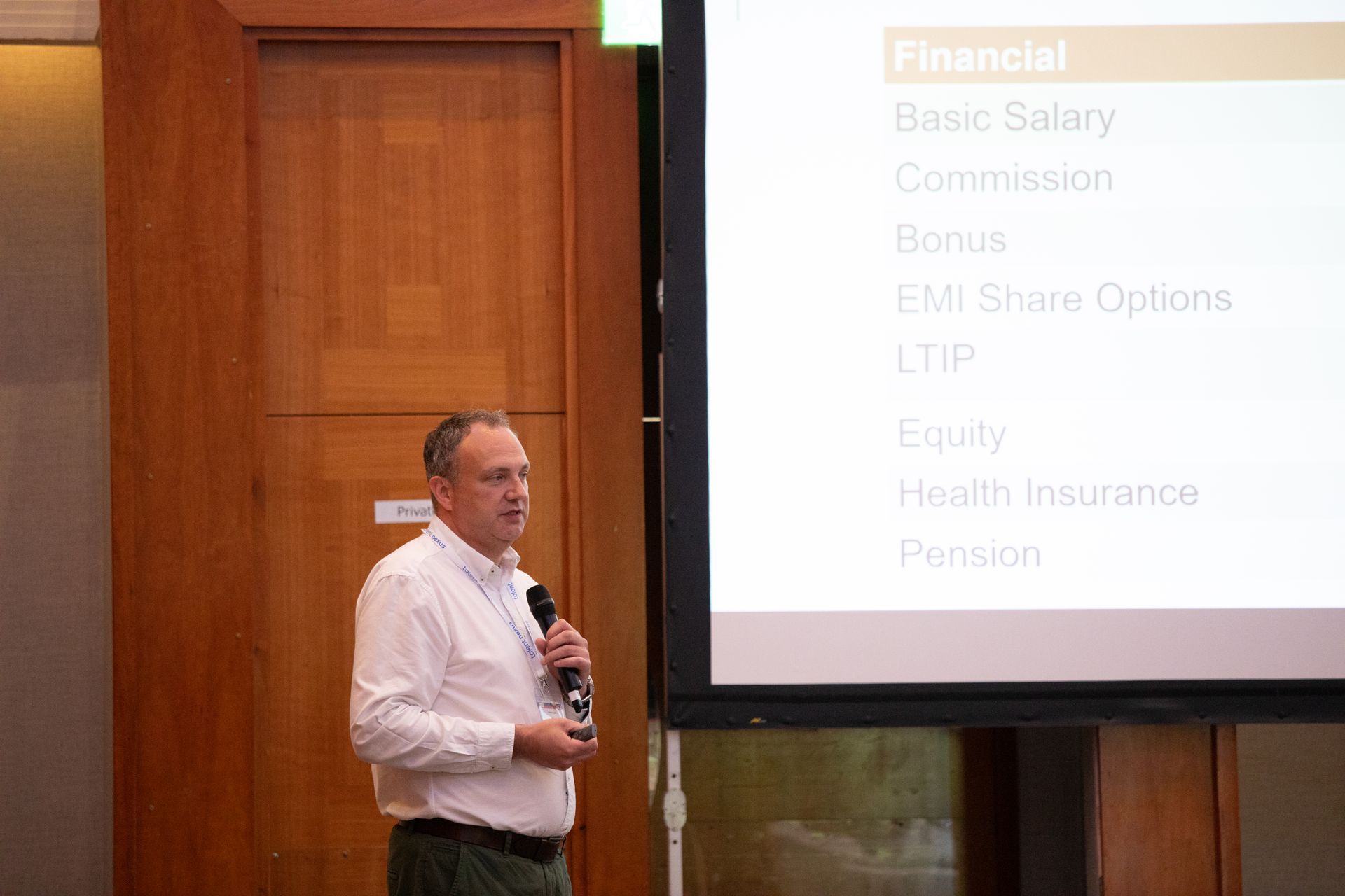A man is giving a presentation in front of a large screen.