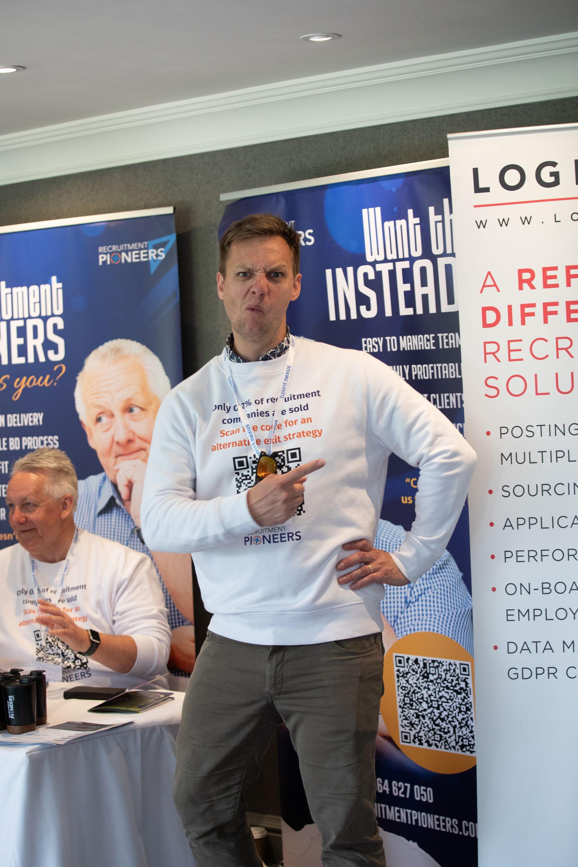 A man is standing in front of a sign that says log instead