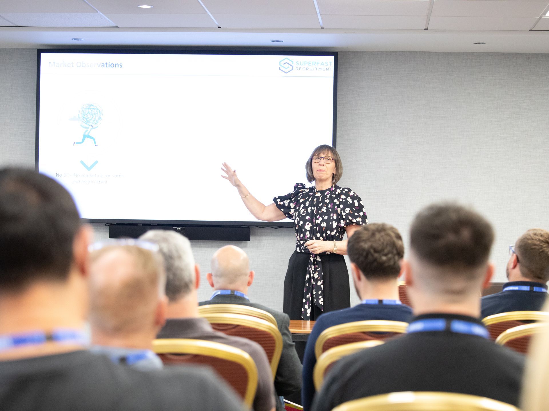 A woman is giving a presentation to a group of people in a conference room.