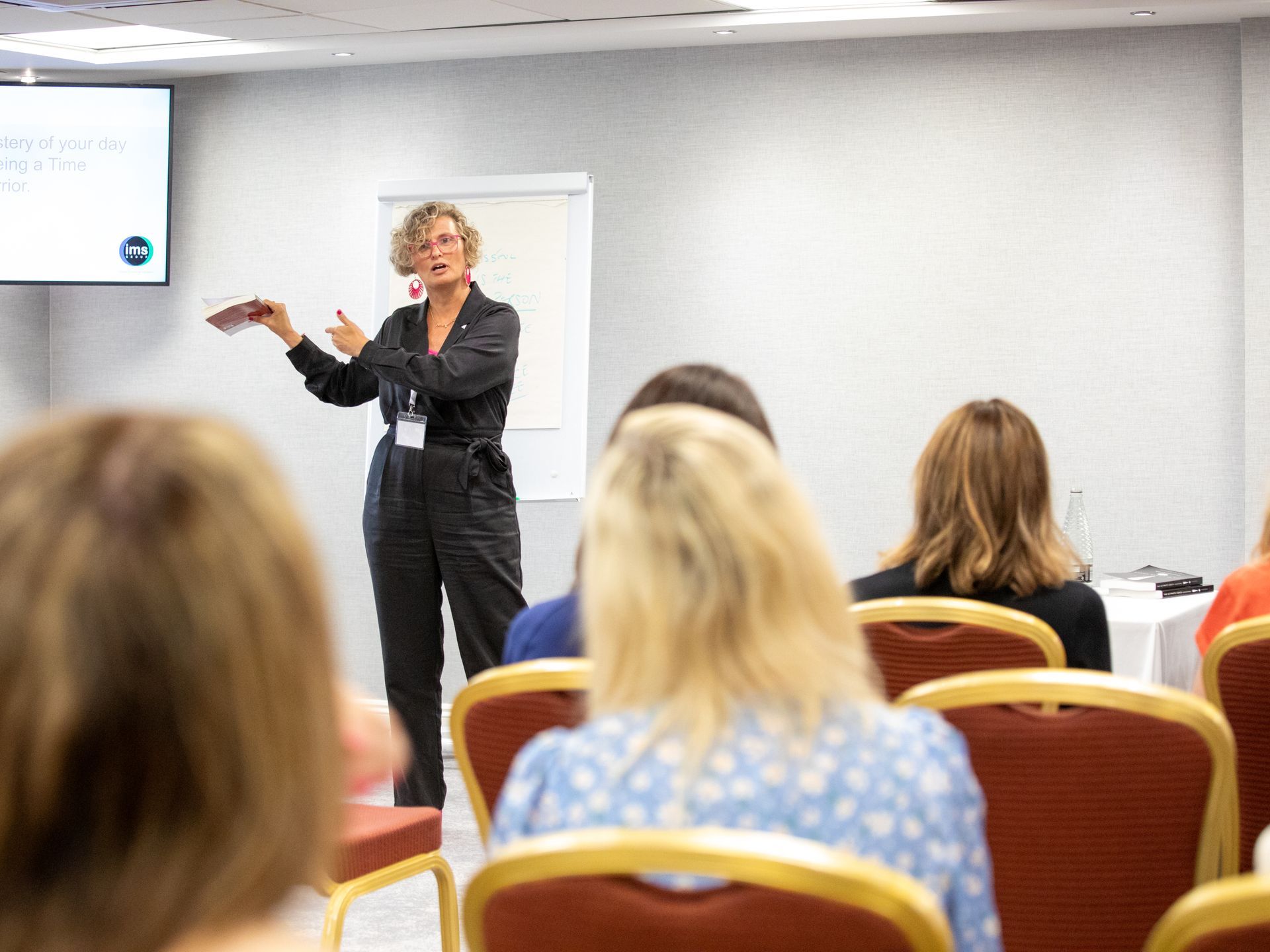 A woman is giving a presentation to a group of people in a conference room.