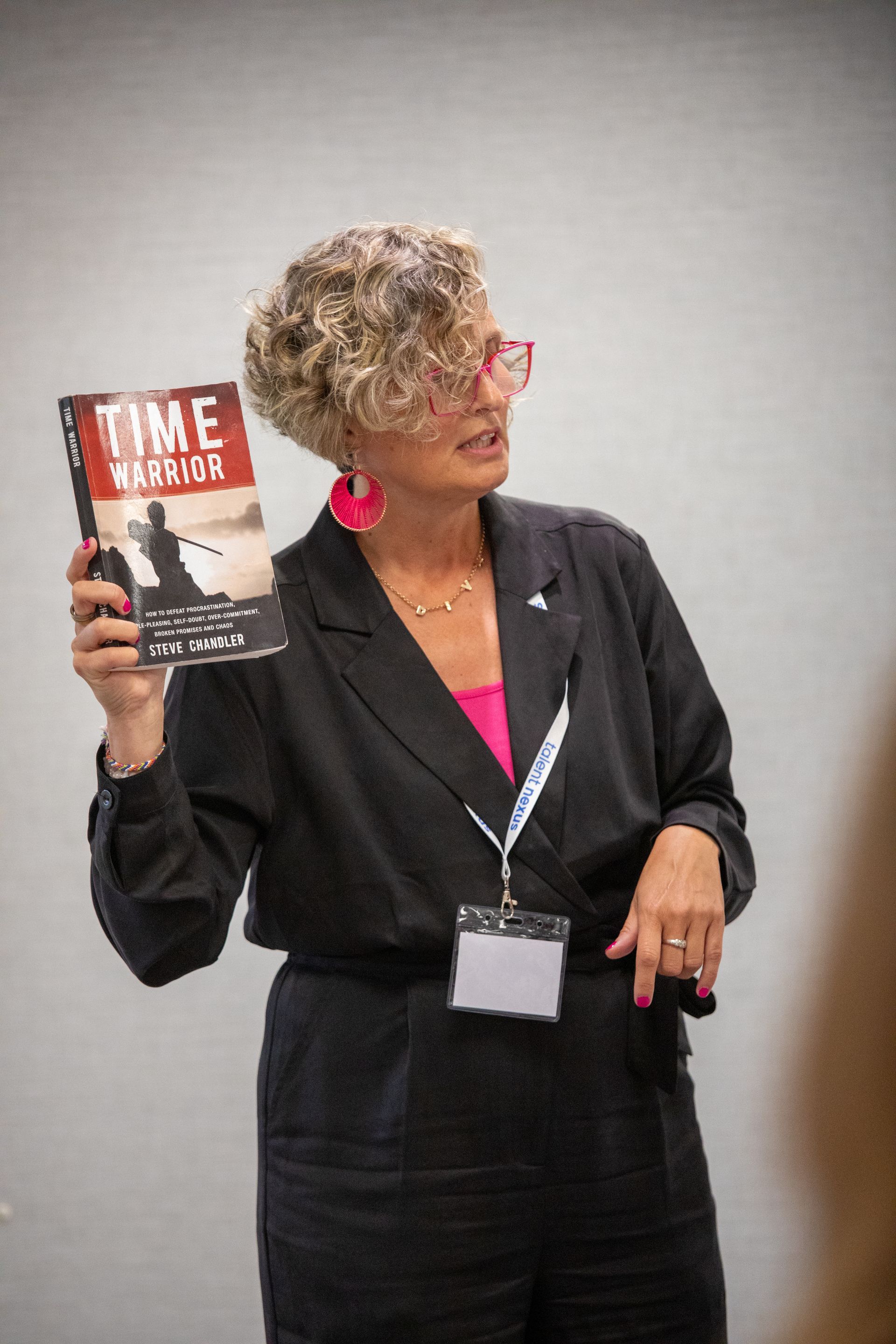 A woman is holding a book titled time warner.