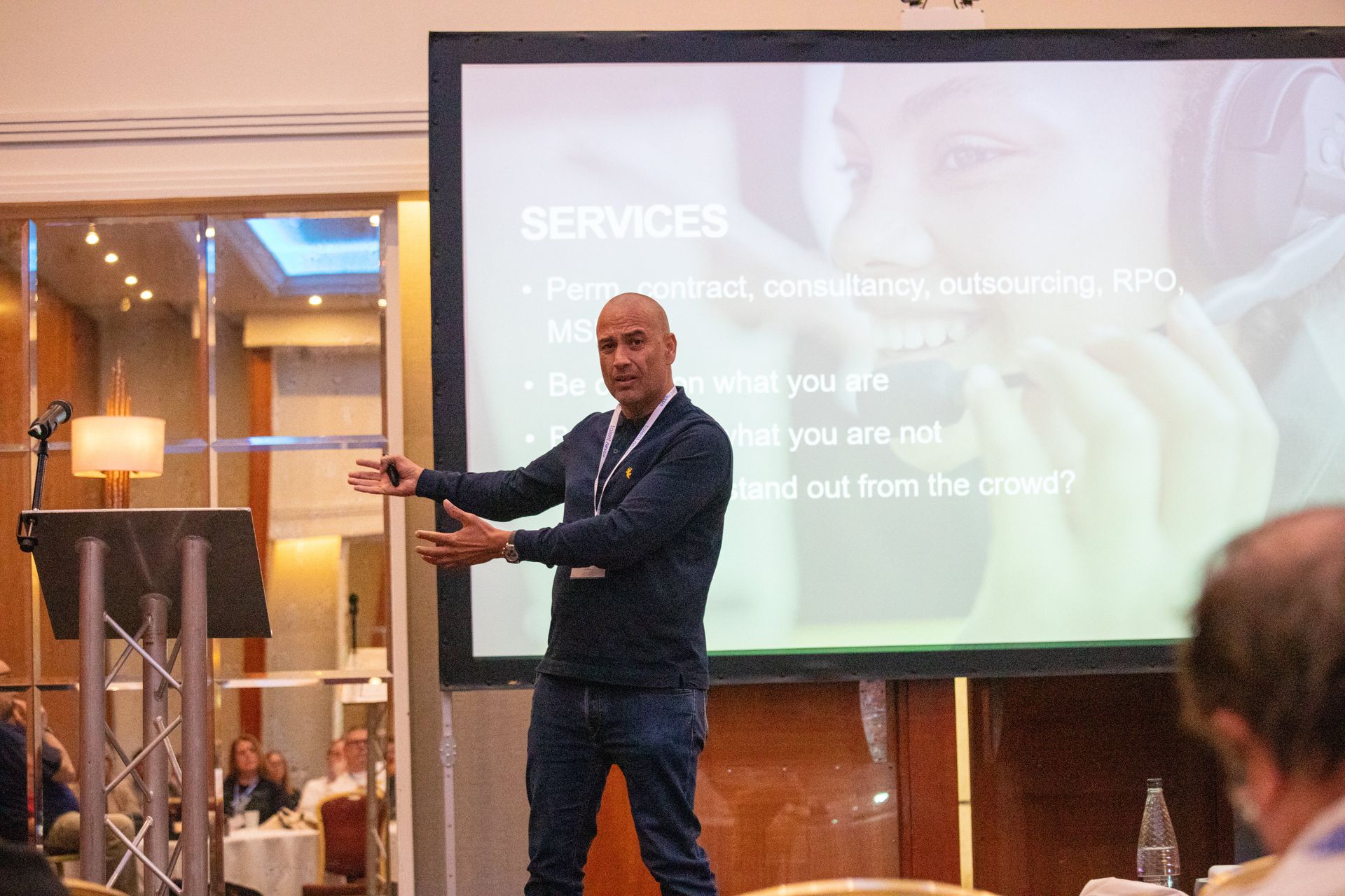A man is giving a presentation in front of a large screen.