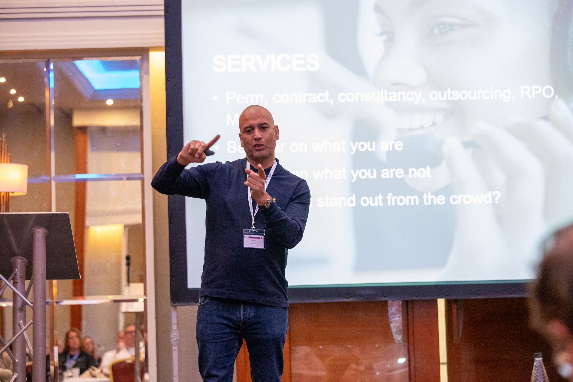 A man is giving a presentation in front of a large screen.