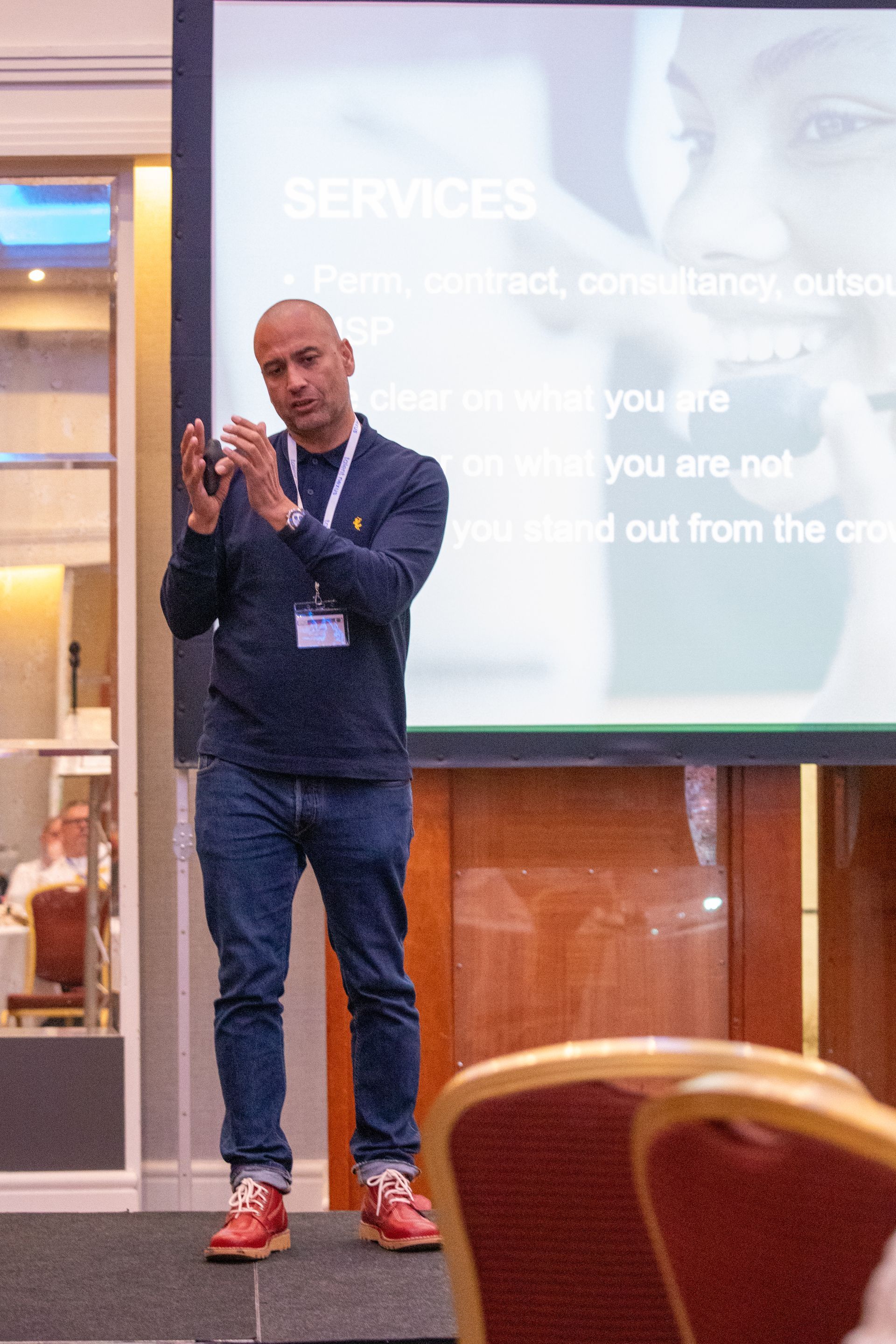 A man is giving a presentation in front of a large screen.