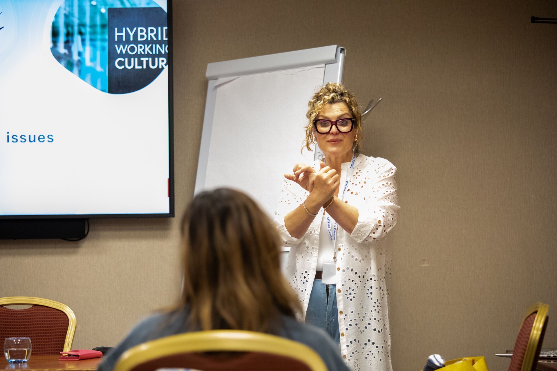 A woman is giving a presentation in front of a group of people.