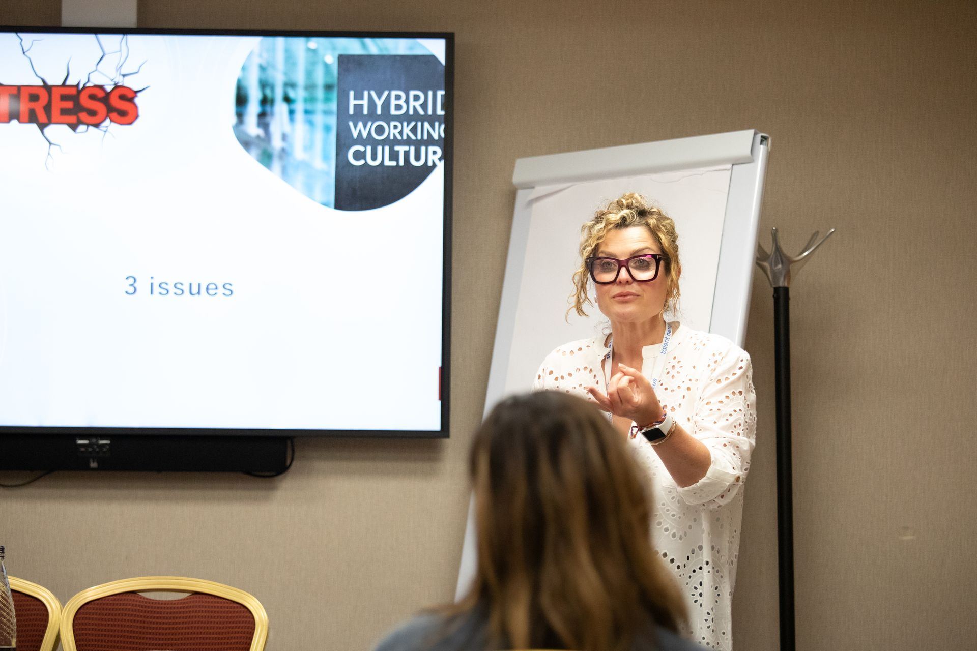 A woman is giving a presentation in front of a group of people.