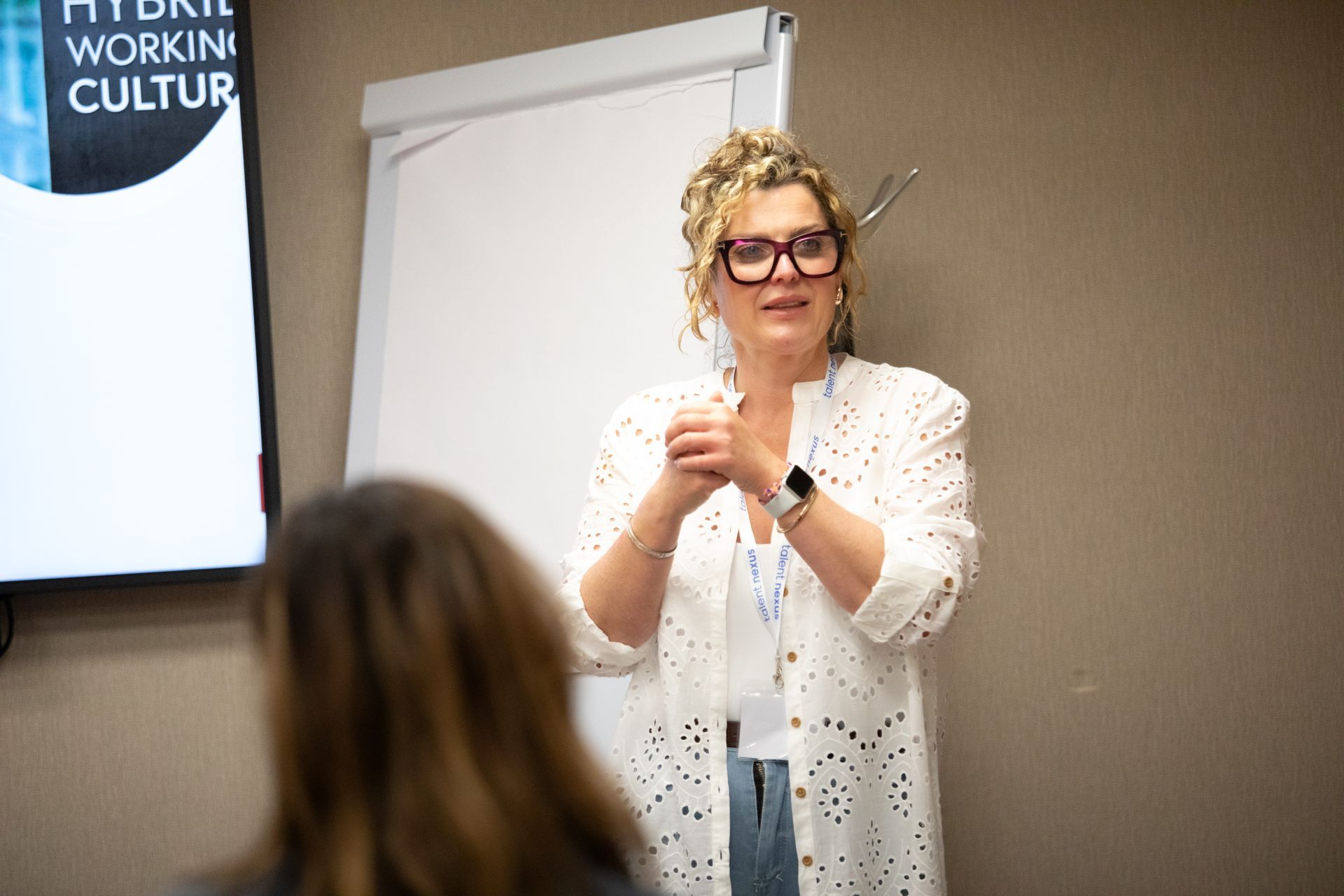 A woman is giving a presentation in front of a group of people.