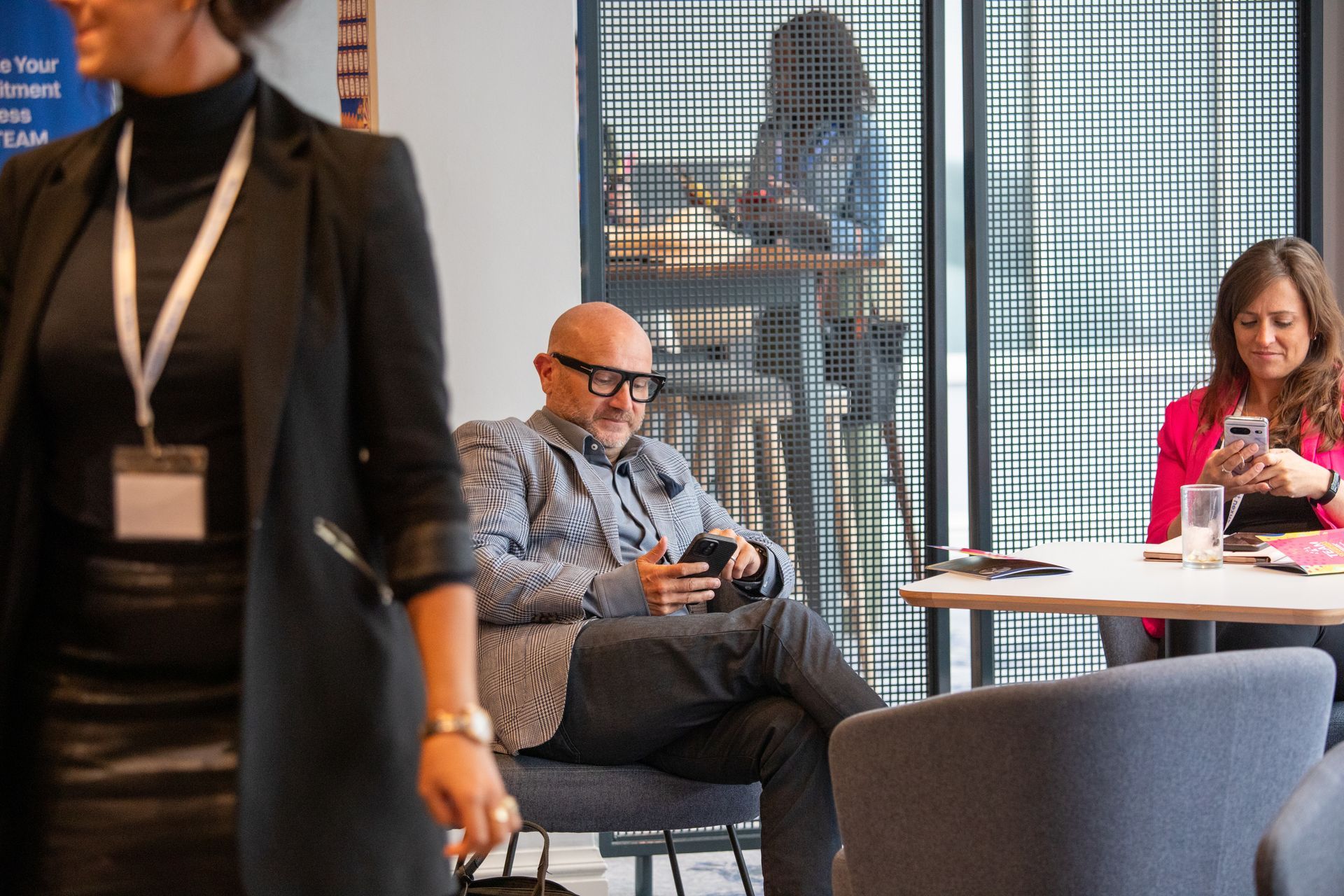 A man is sitting in a chair looking at his cell phone.