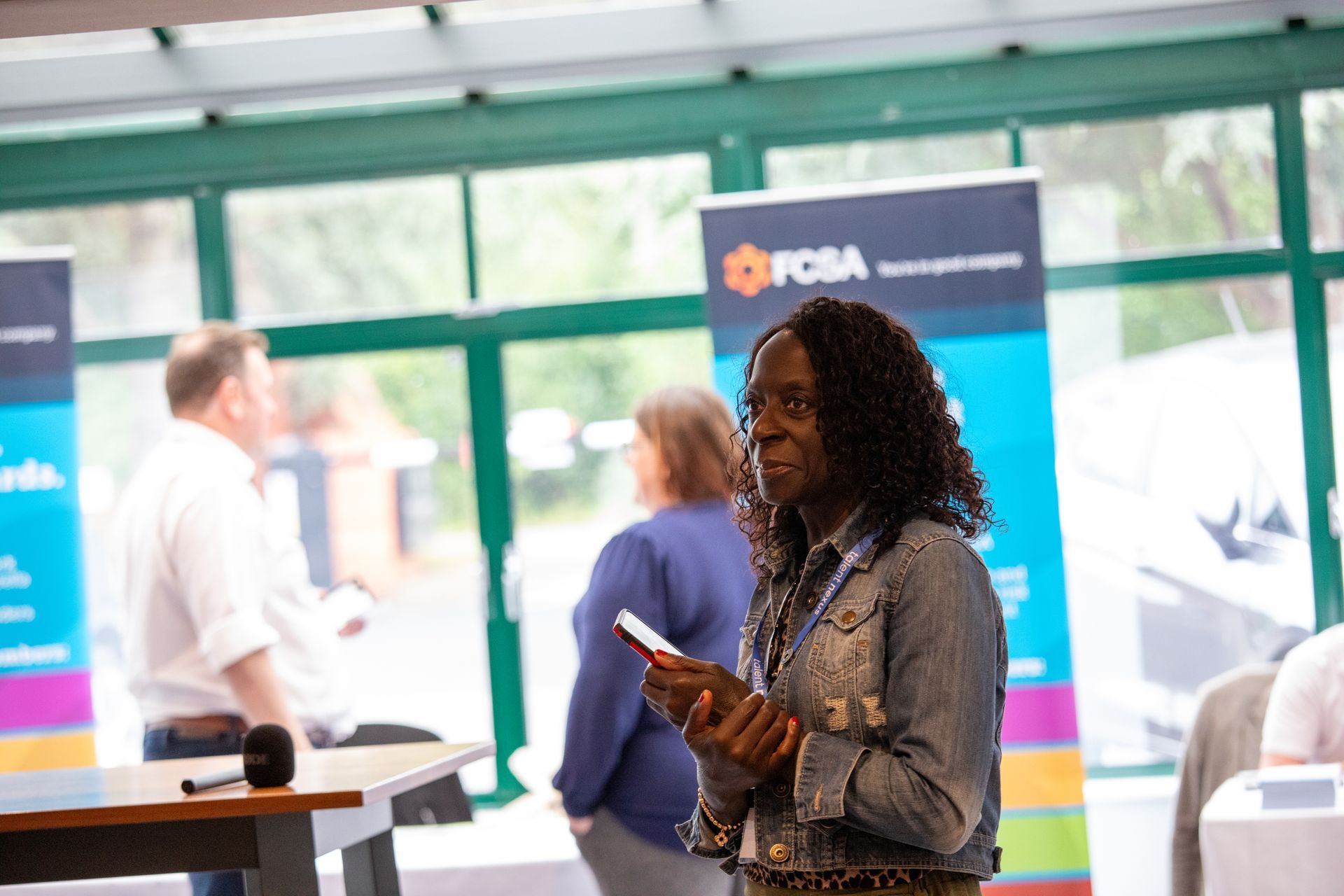 A woman is standing in a room holding a cell phone.