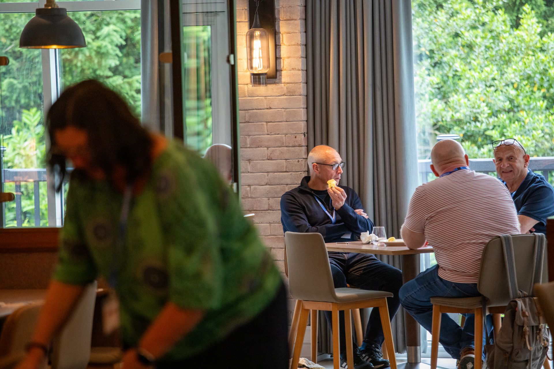 A group of people are sitting at tables in a restaurant.