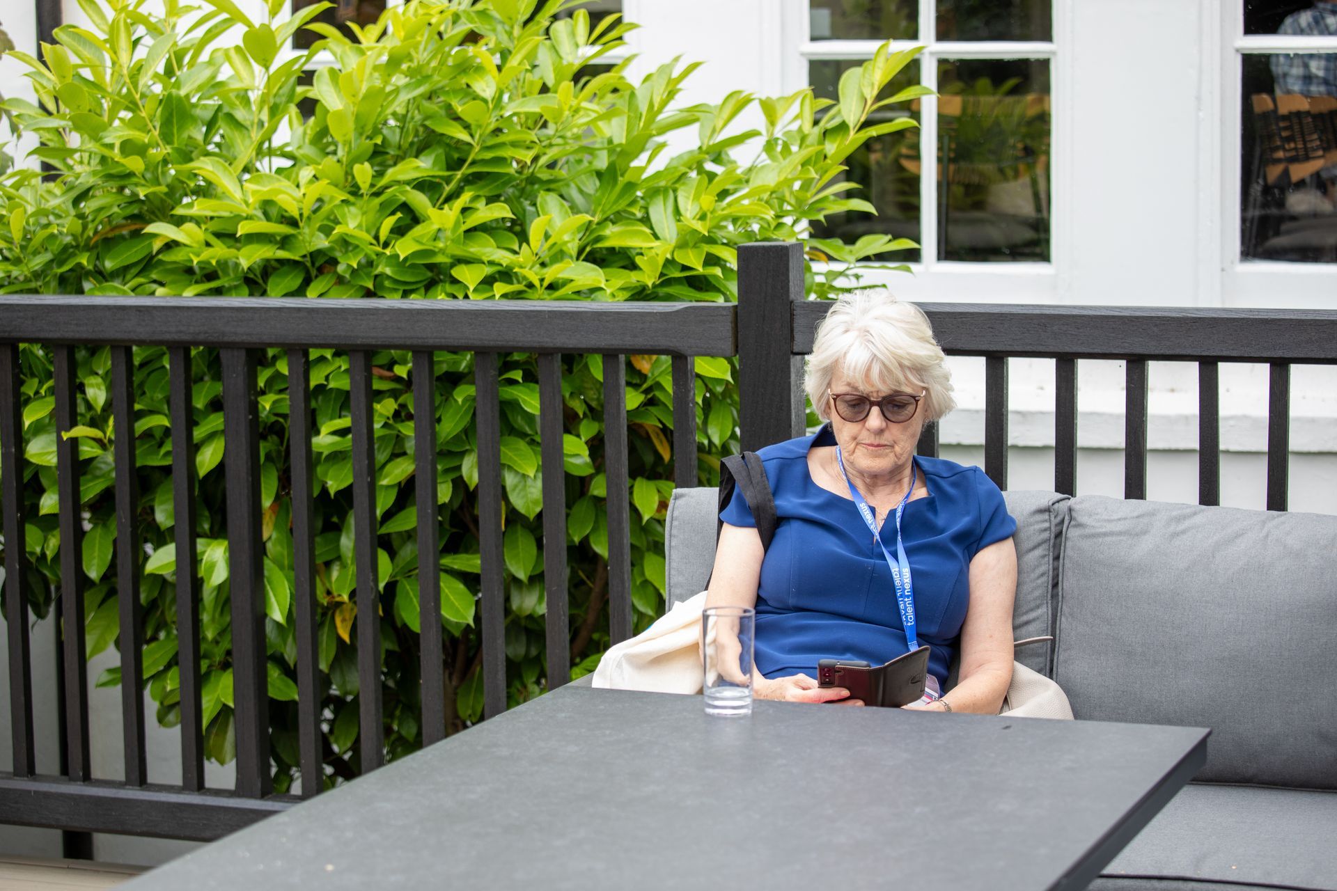 A woman is sitting on a couch looking at her phone.