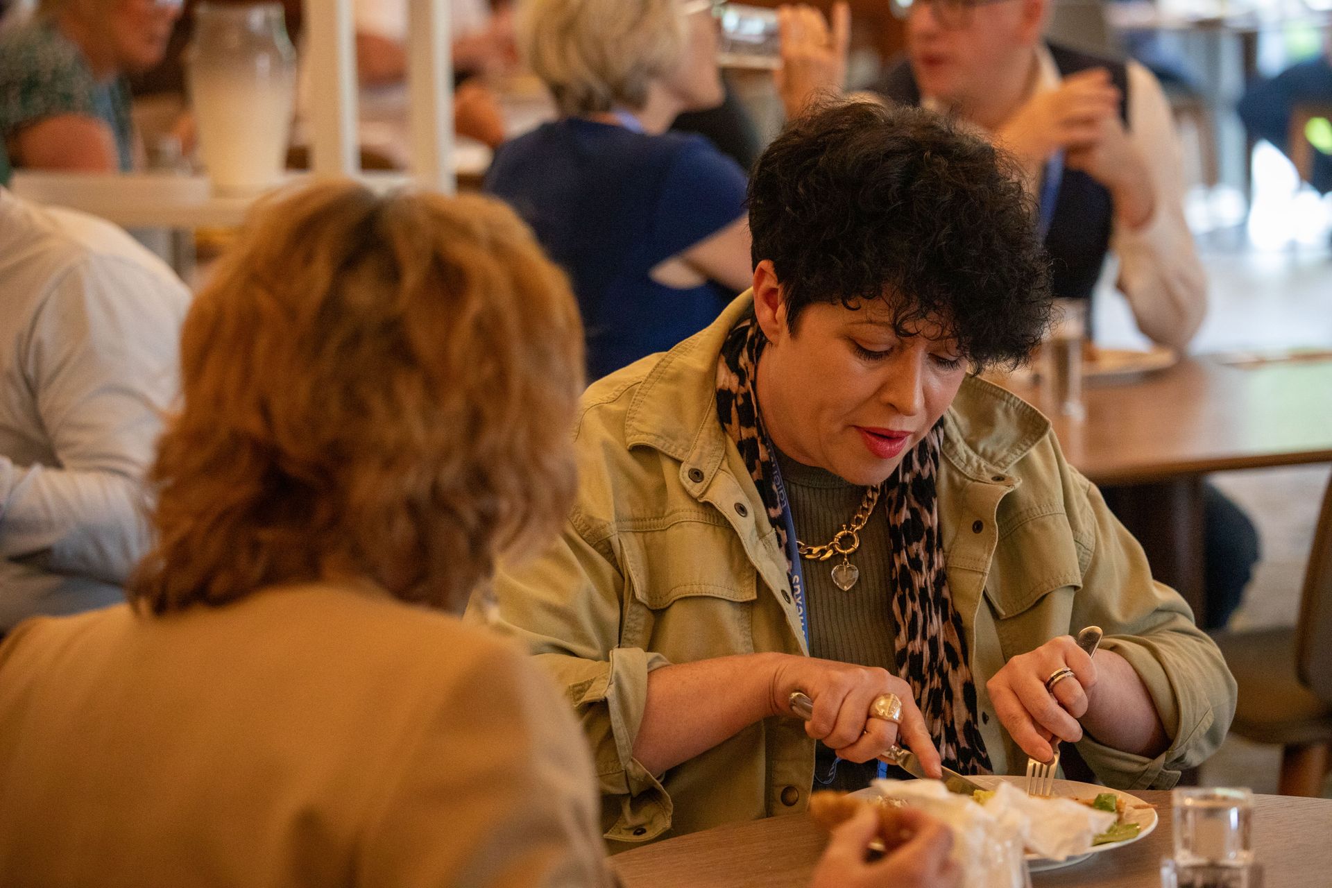 Two women are sitting at a table in a restaurant eating food.