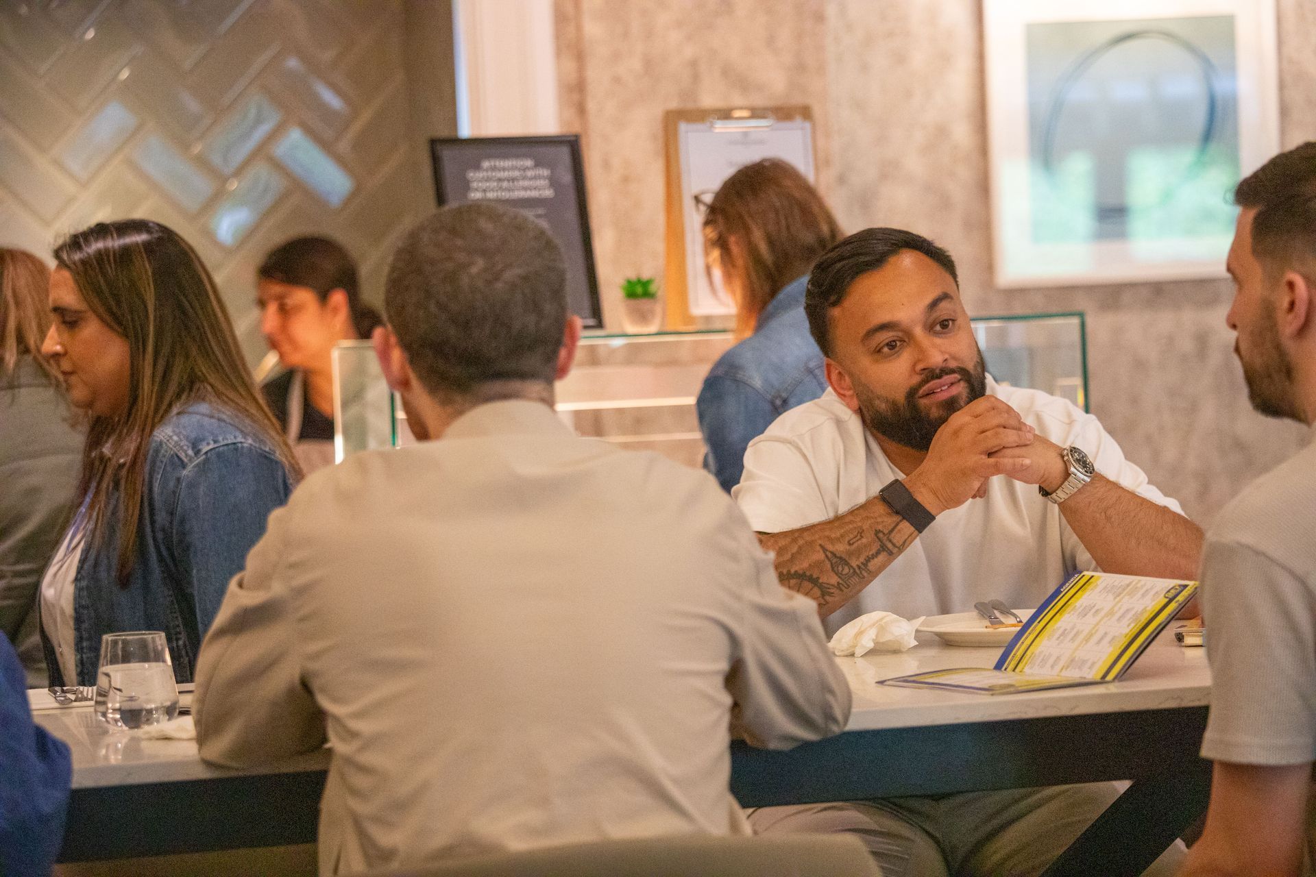 A group of people are sitting at a table in a restaurant.