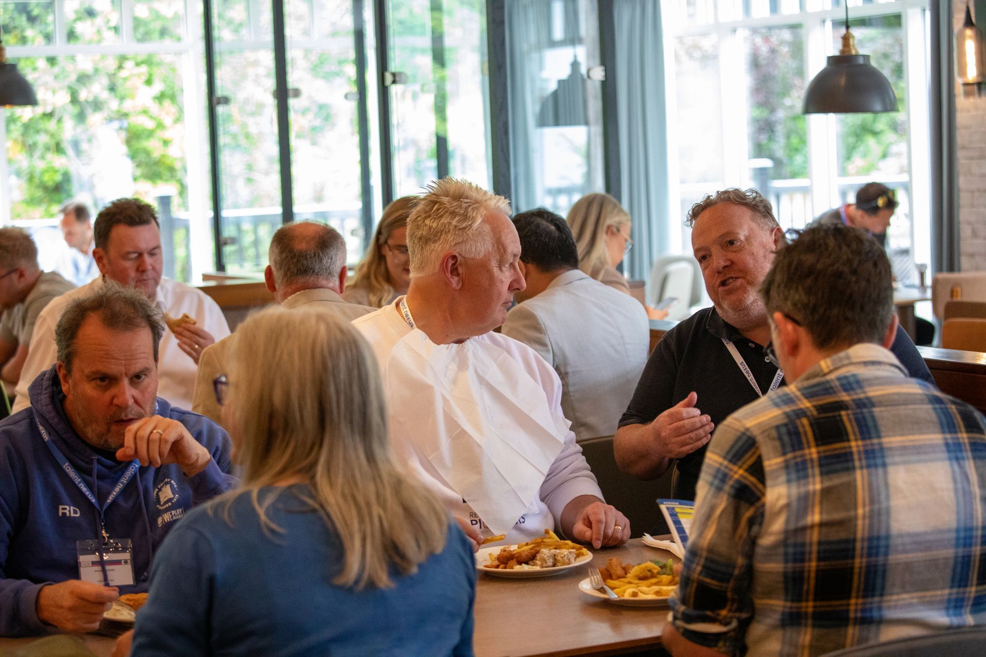 A group of people are sitting at tables in a restaurant eating food.