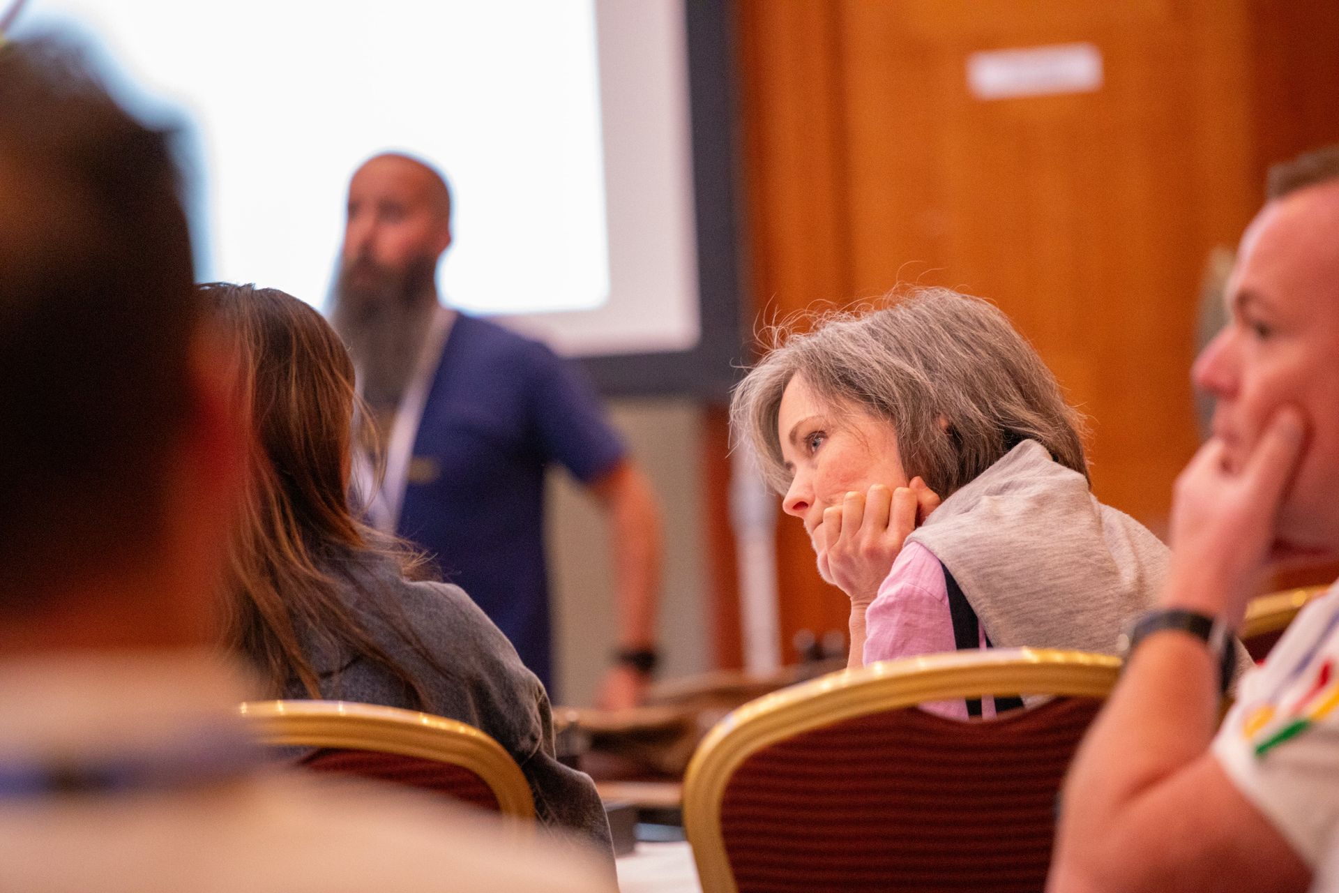A group of people are sitting in chairs listening to a presentation.