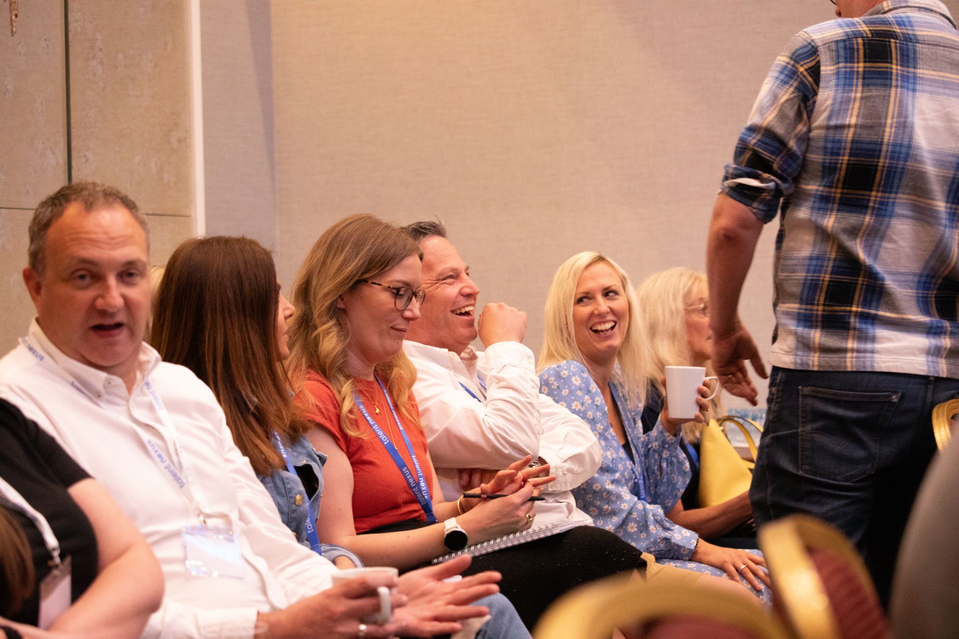 A group of people are sitting in a room and laughing.