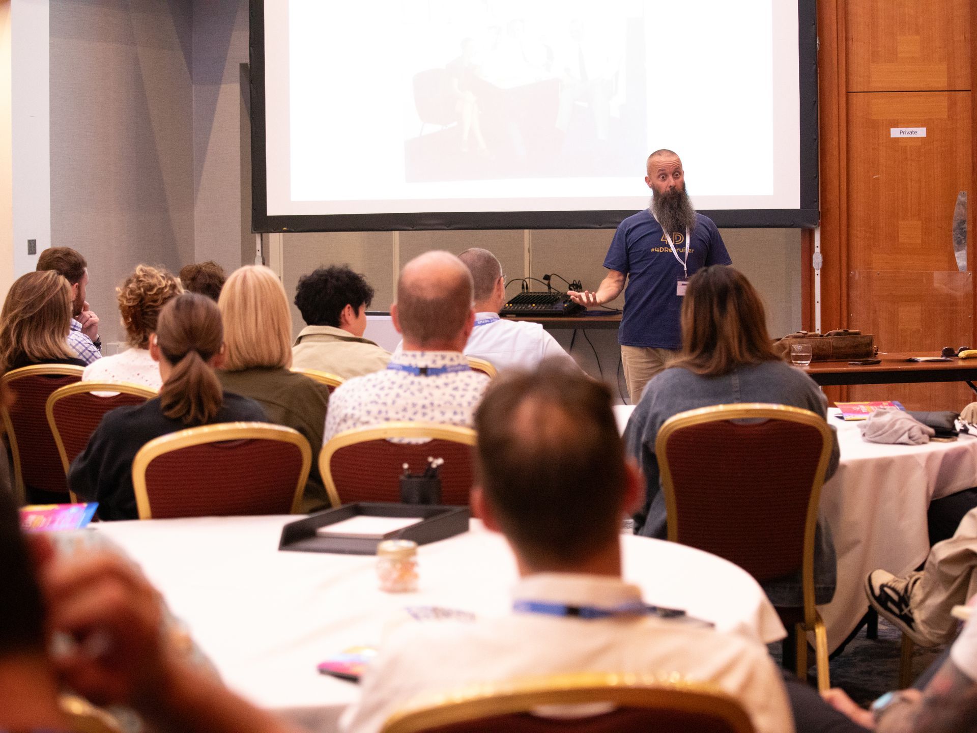 A man is giving a presentation to a group of people in a conference room.