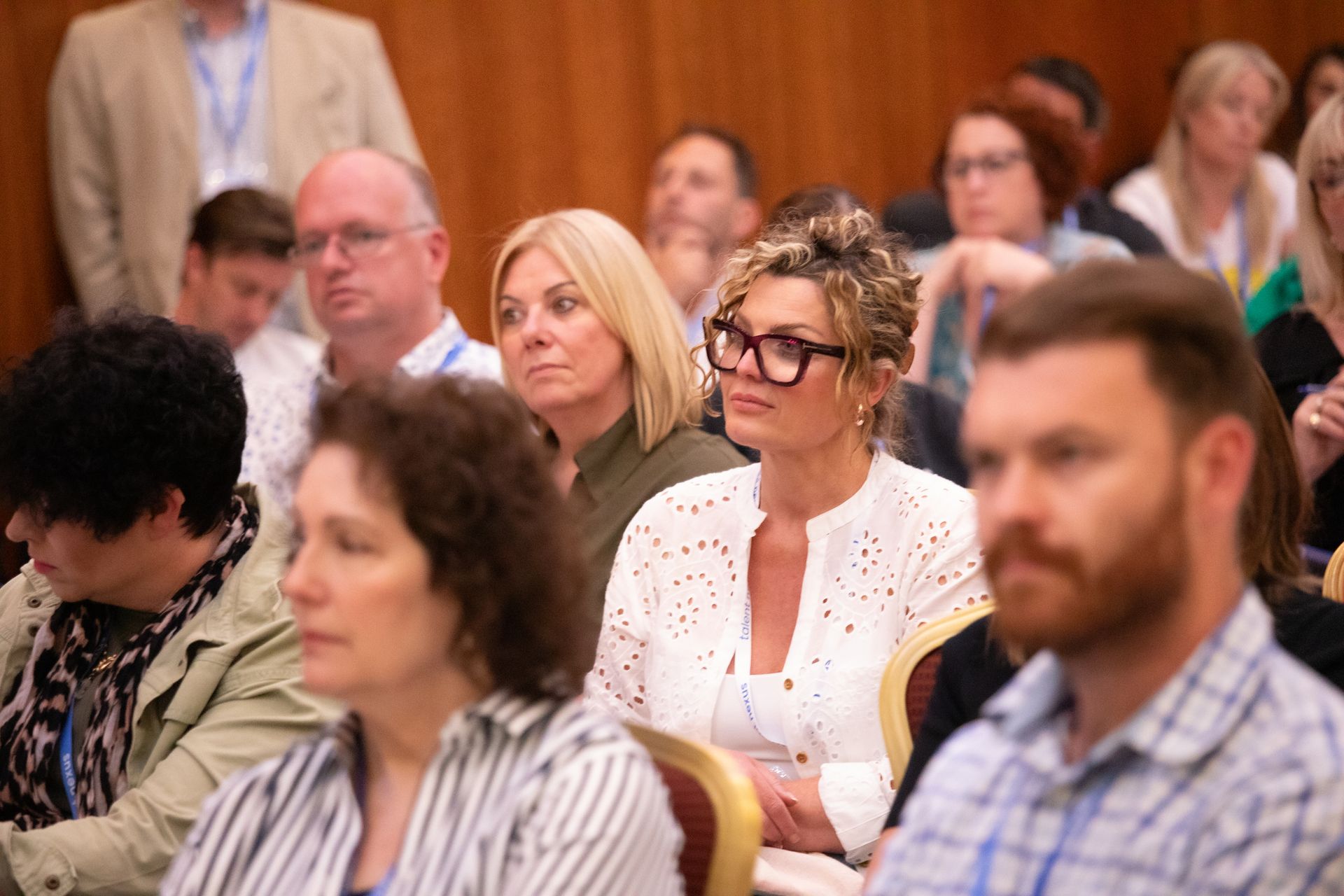 A group of people are sitting in a room watching a presentation.