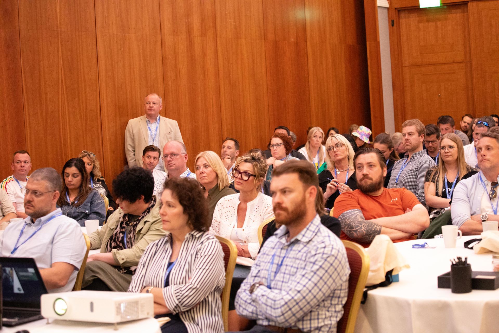 A large group of people are sitting at tables in a conference room.