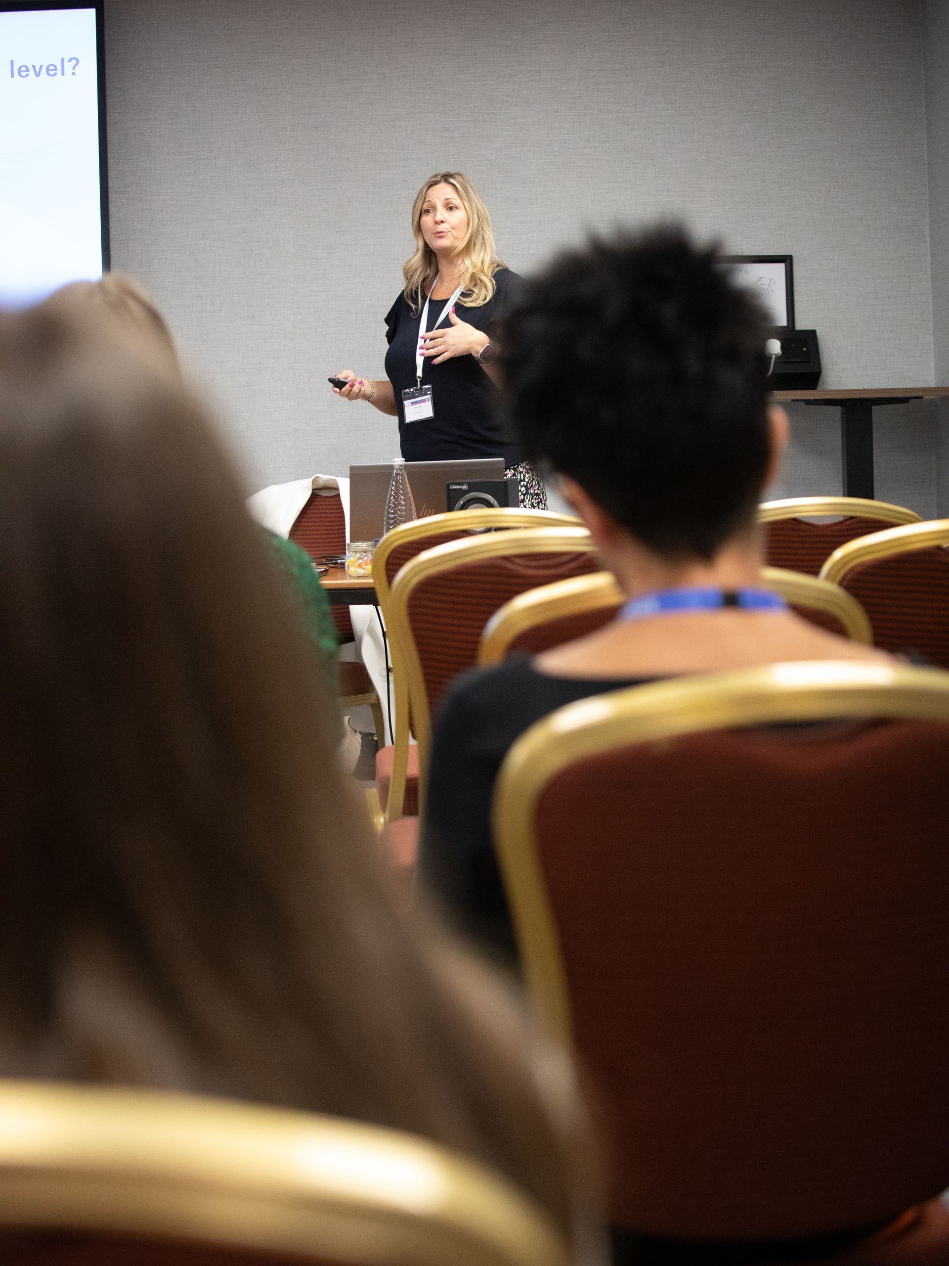 A woman is giving a presentation to a group of people in a conference room.