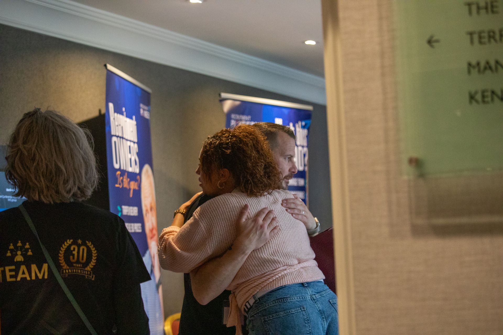 A group of people are hugging each other in a room.