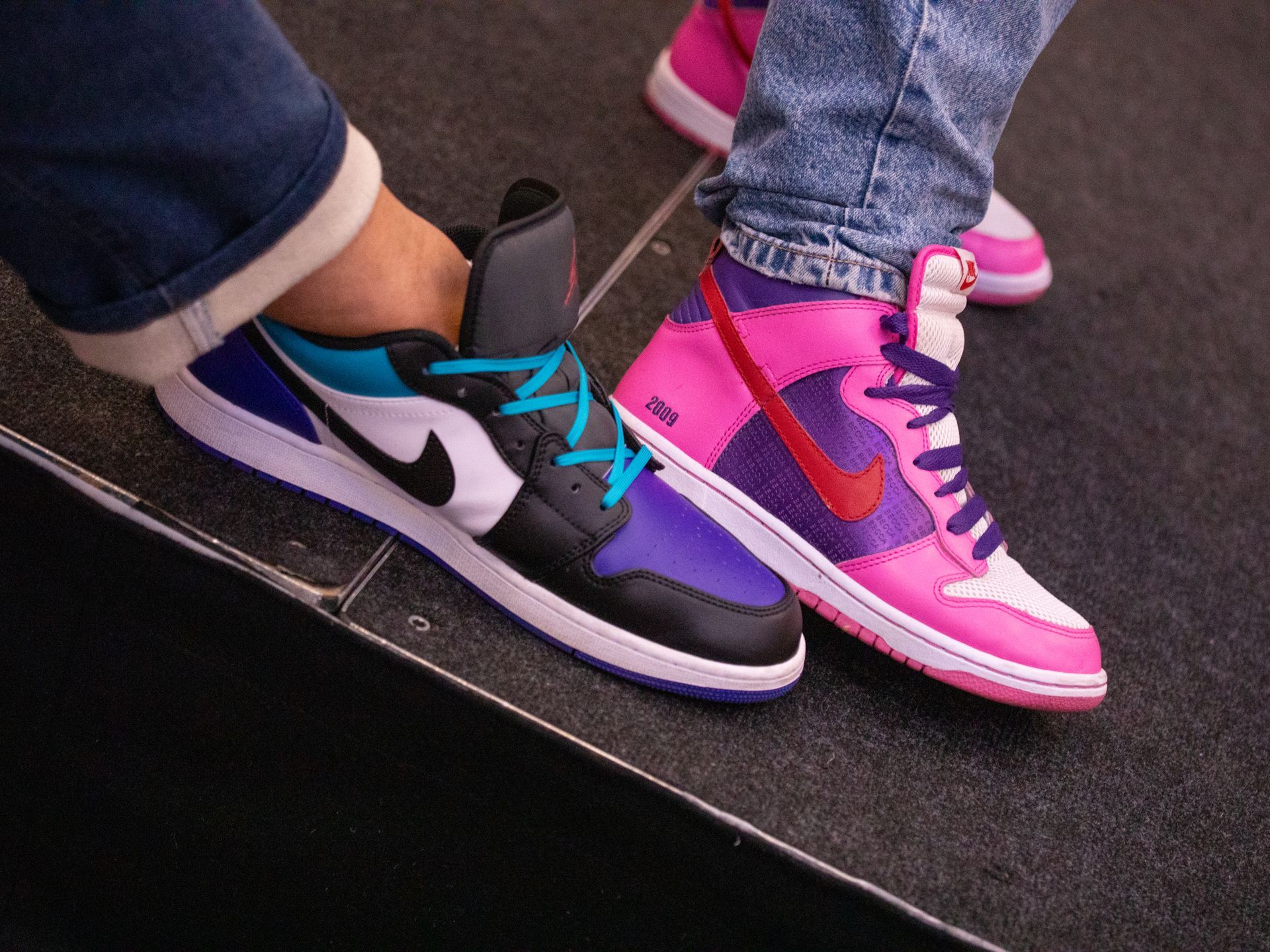 A person wearing a pair of pink and purple nike shoes