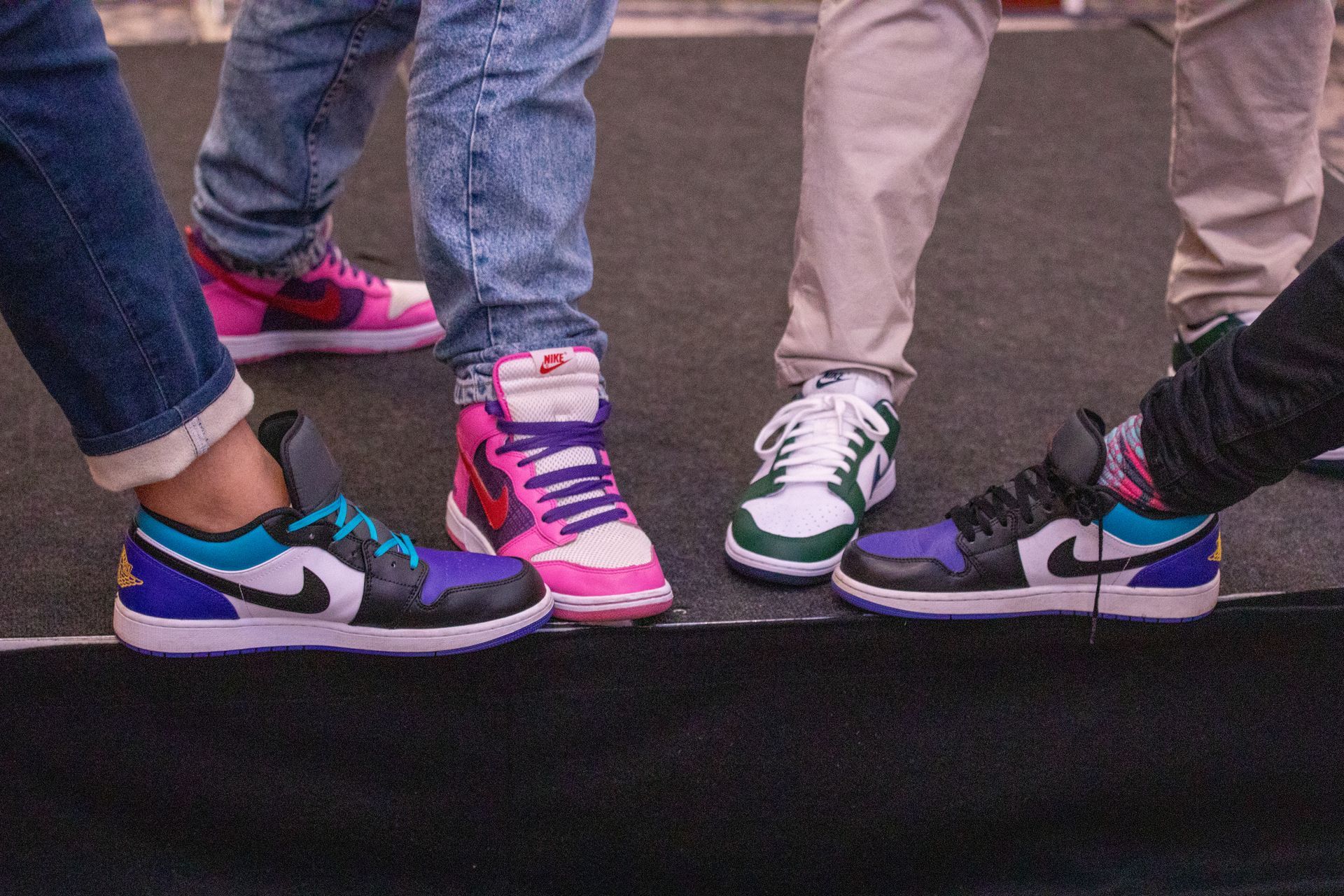 A group of people standing next to each other wearing nike shoes.