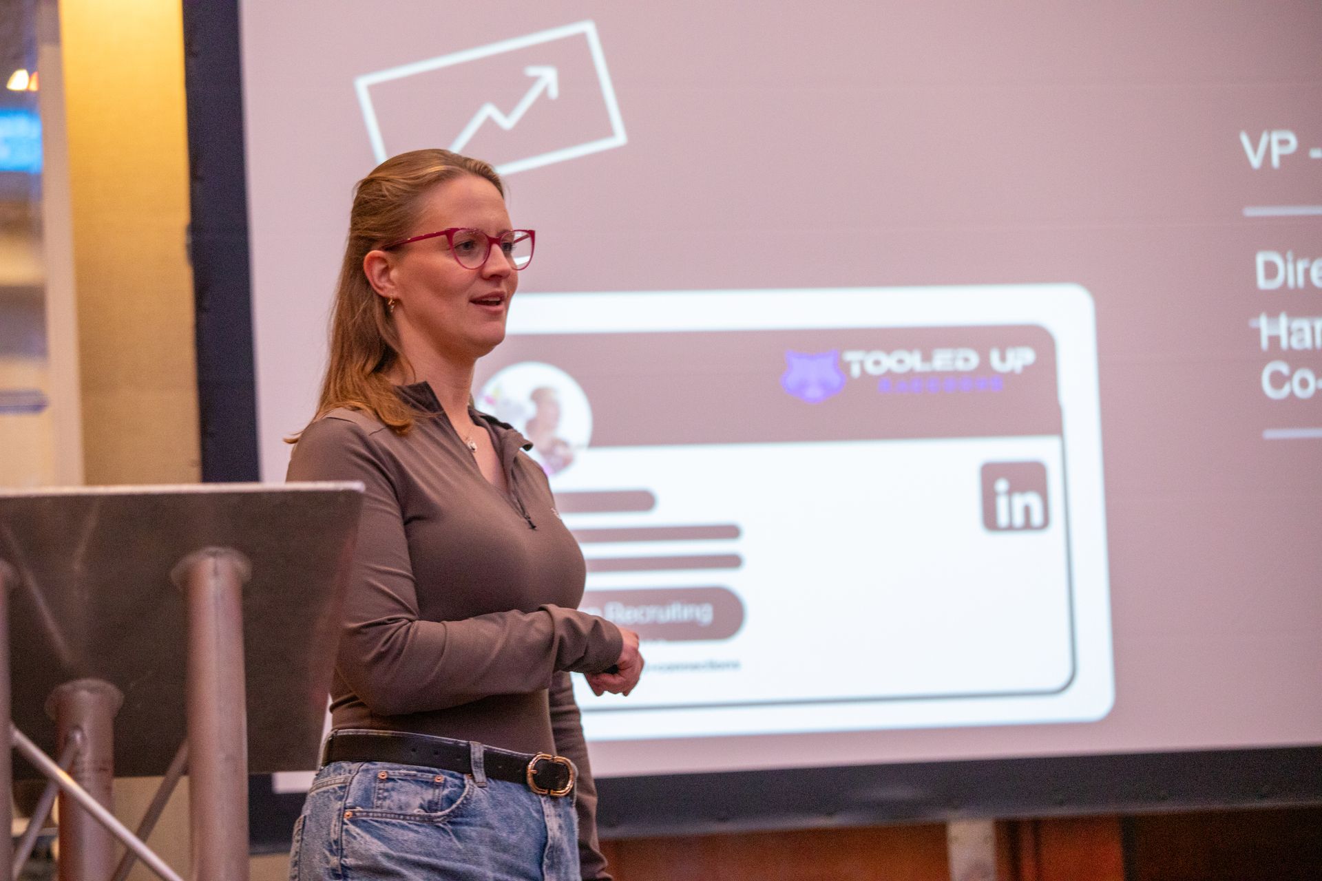 A woman is giving a presentation in front of a screen that says linkedin