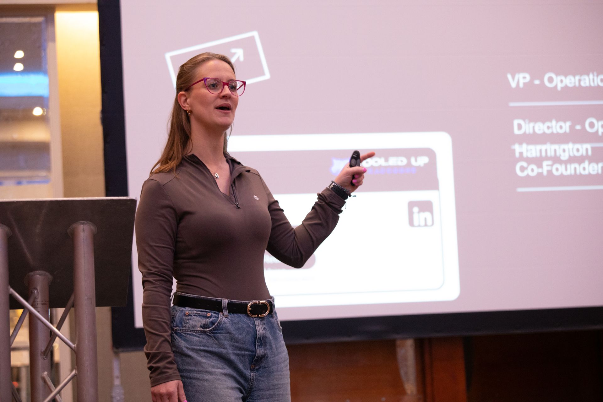 A woman is giving a presentation in front of a large screen