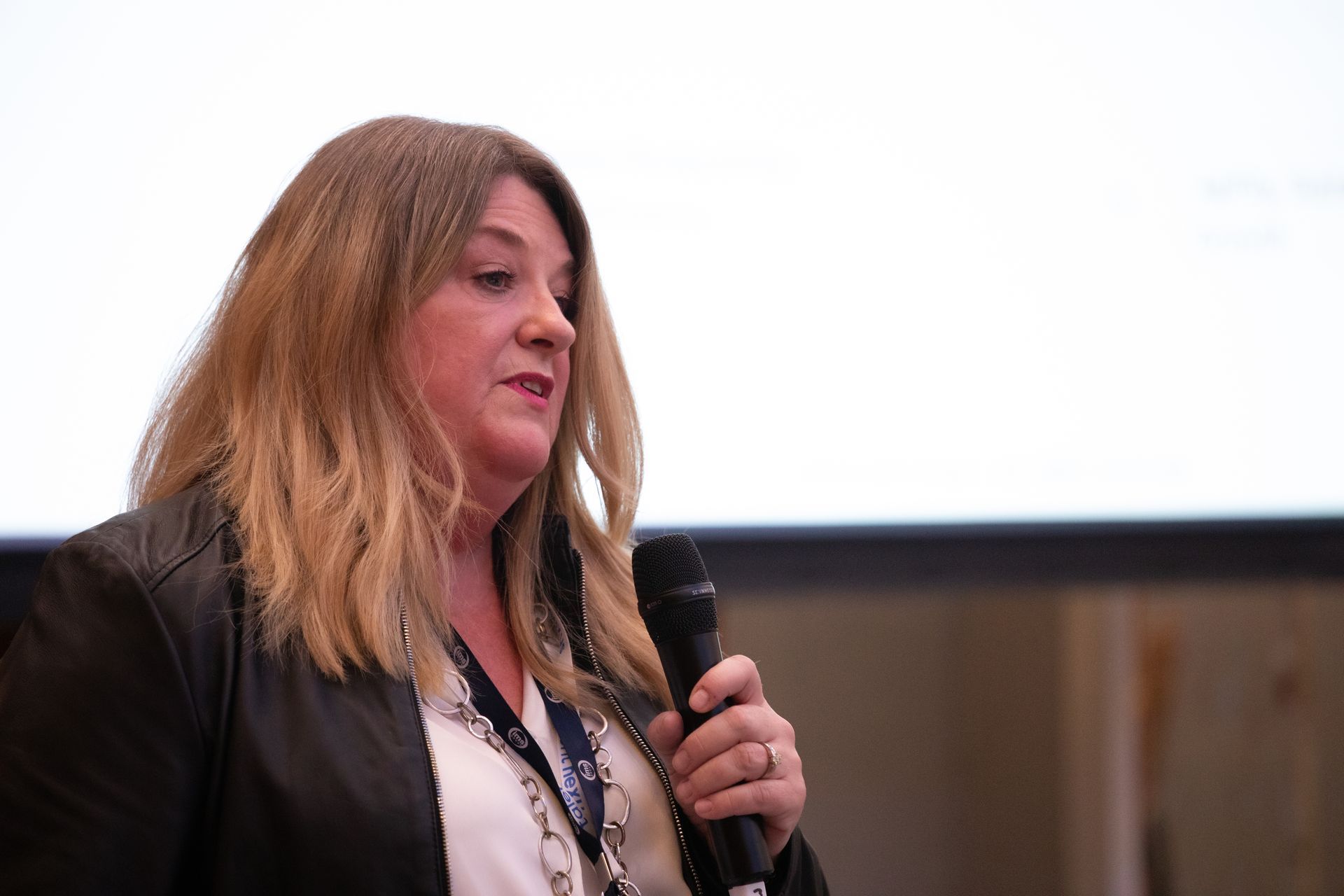 A woman is holding a microphone and speaking into it.