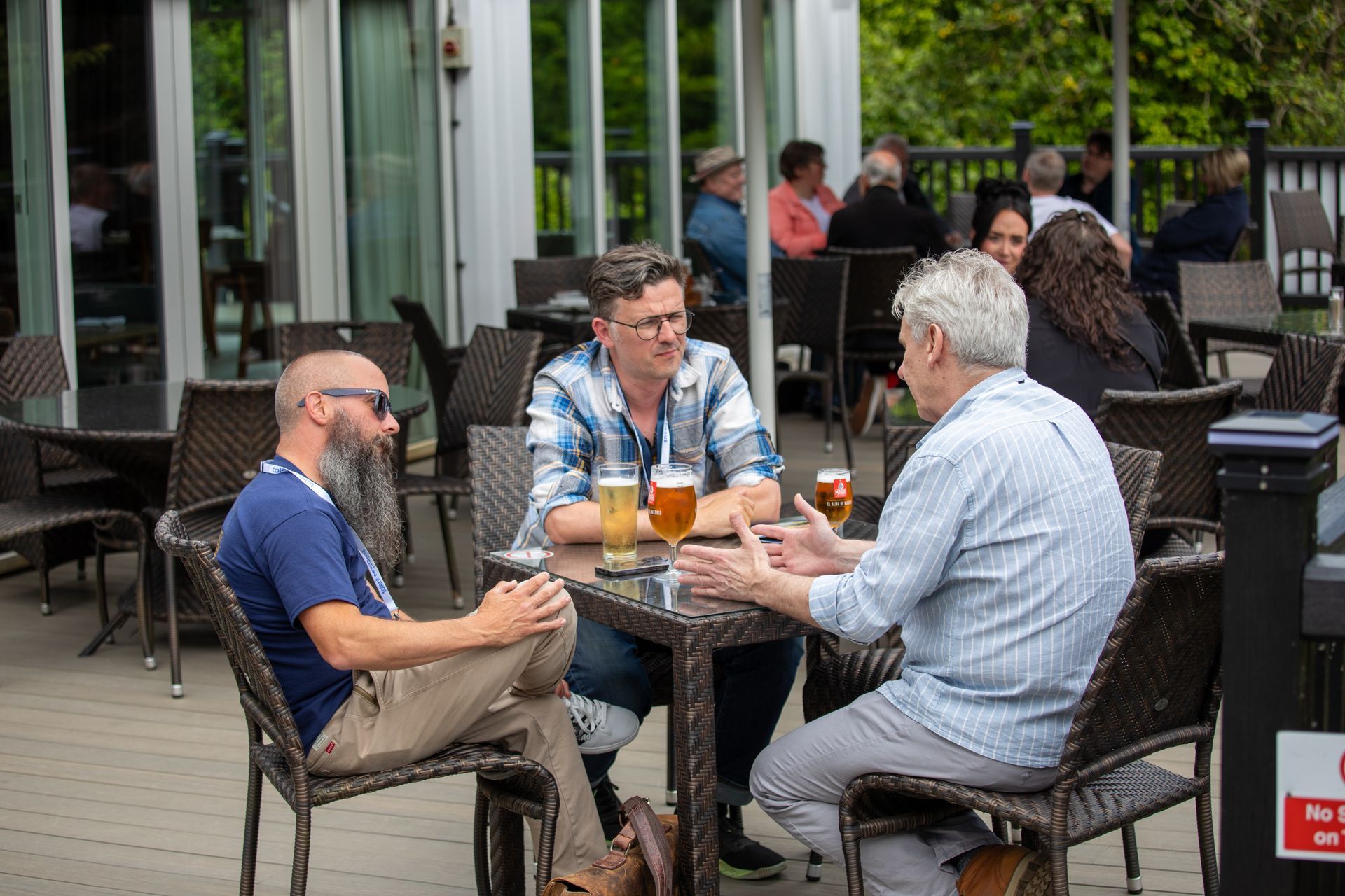 A group of people are sitting at a table drinking beer.