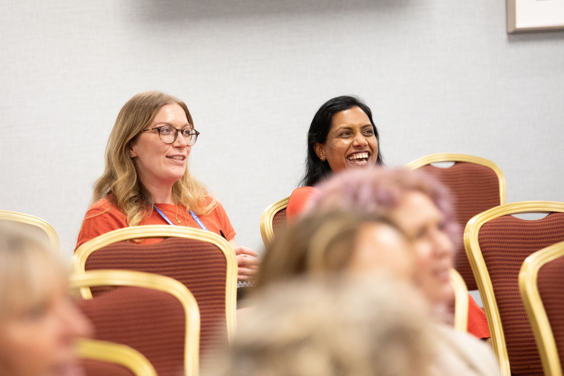 A group of women are sitting in chairs at a conference.