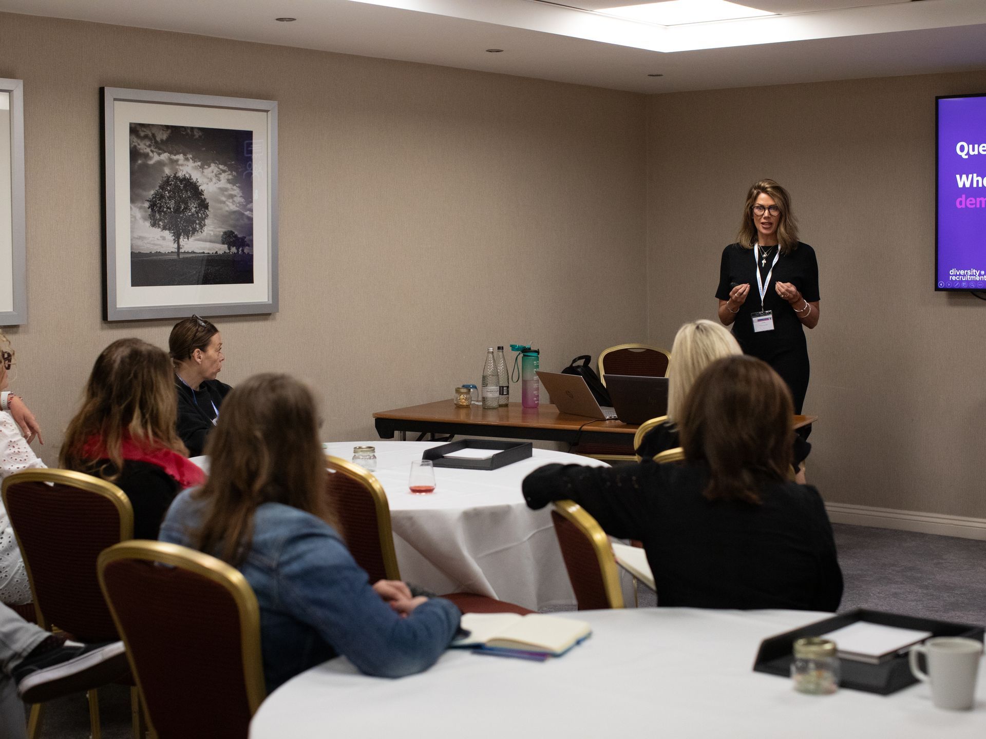 A woman is giving a presentation to a group of people in a conference room.