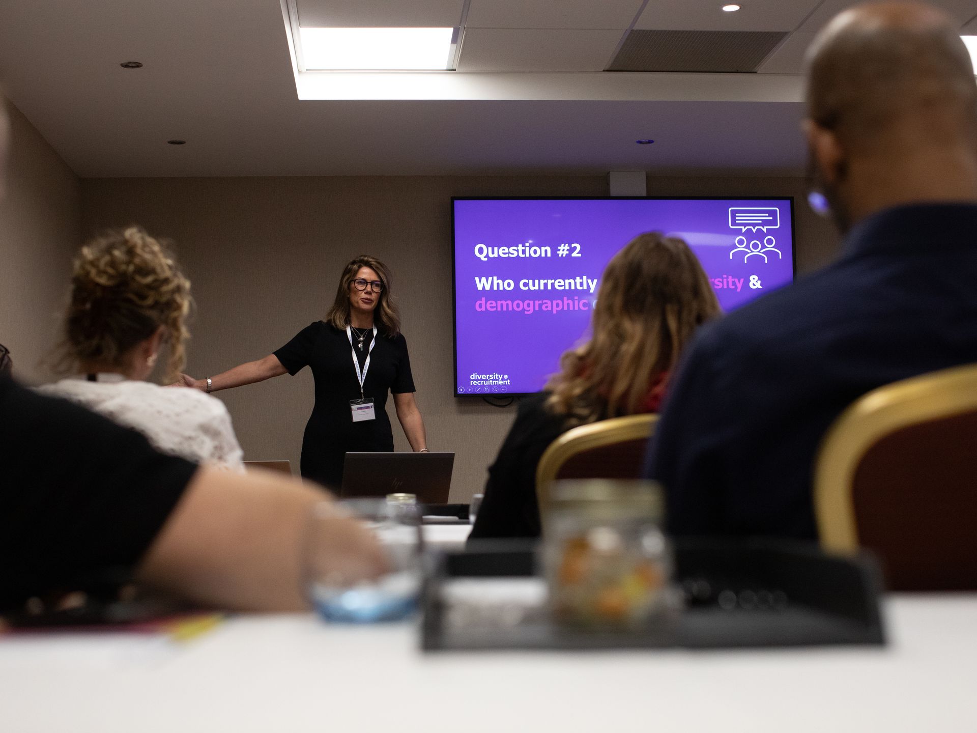 A woman is giving a presentation to a group of people in a conference room.