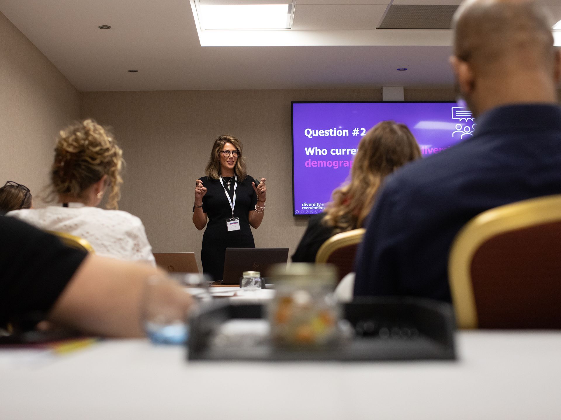 A woman is giving a presentation to a group of people in a conference room.