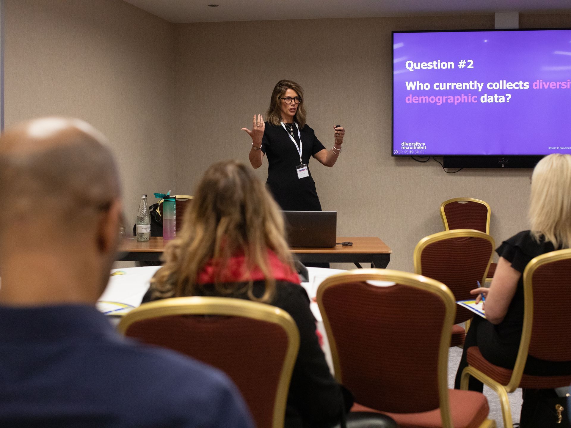 A woman is giving a presentation to a group of people in a conference room.