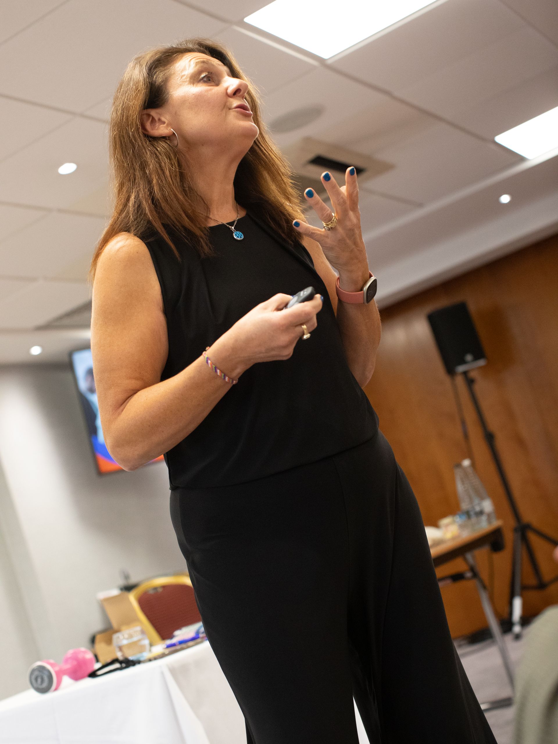 A woman is standing in a room giving a presentation.