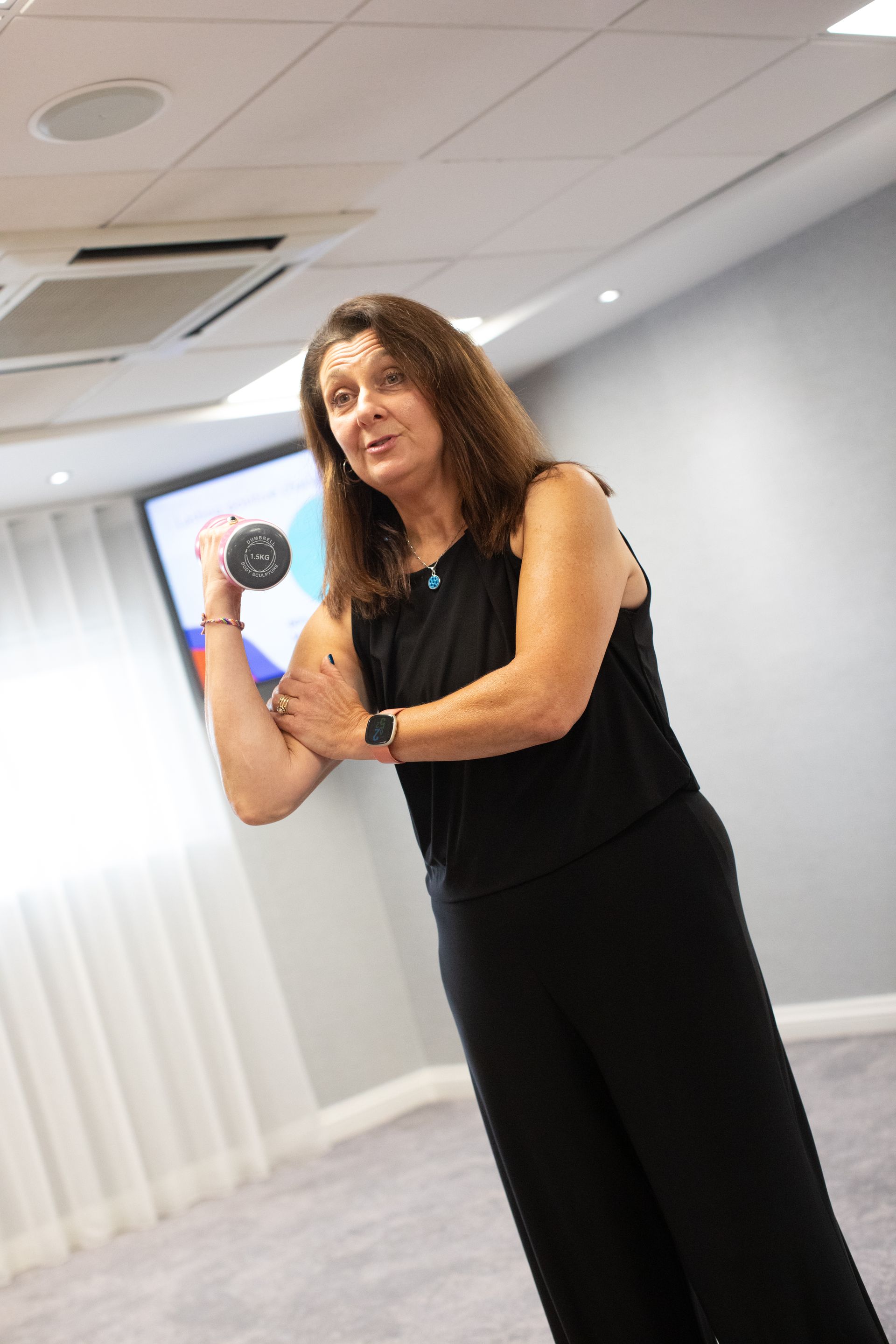 A woman is standing in a room holding a microphone.