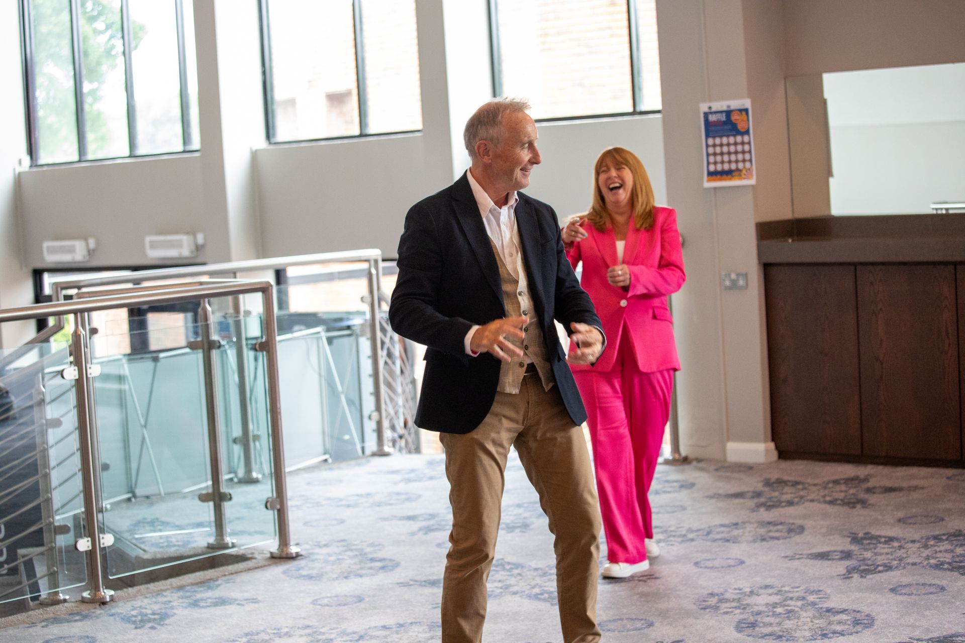 A man and a woman are dancing in a hallway.
