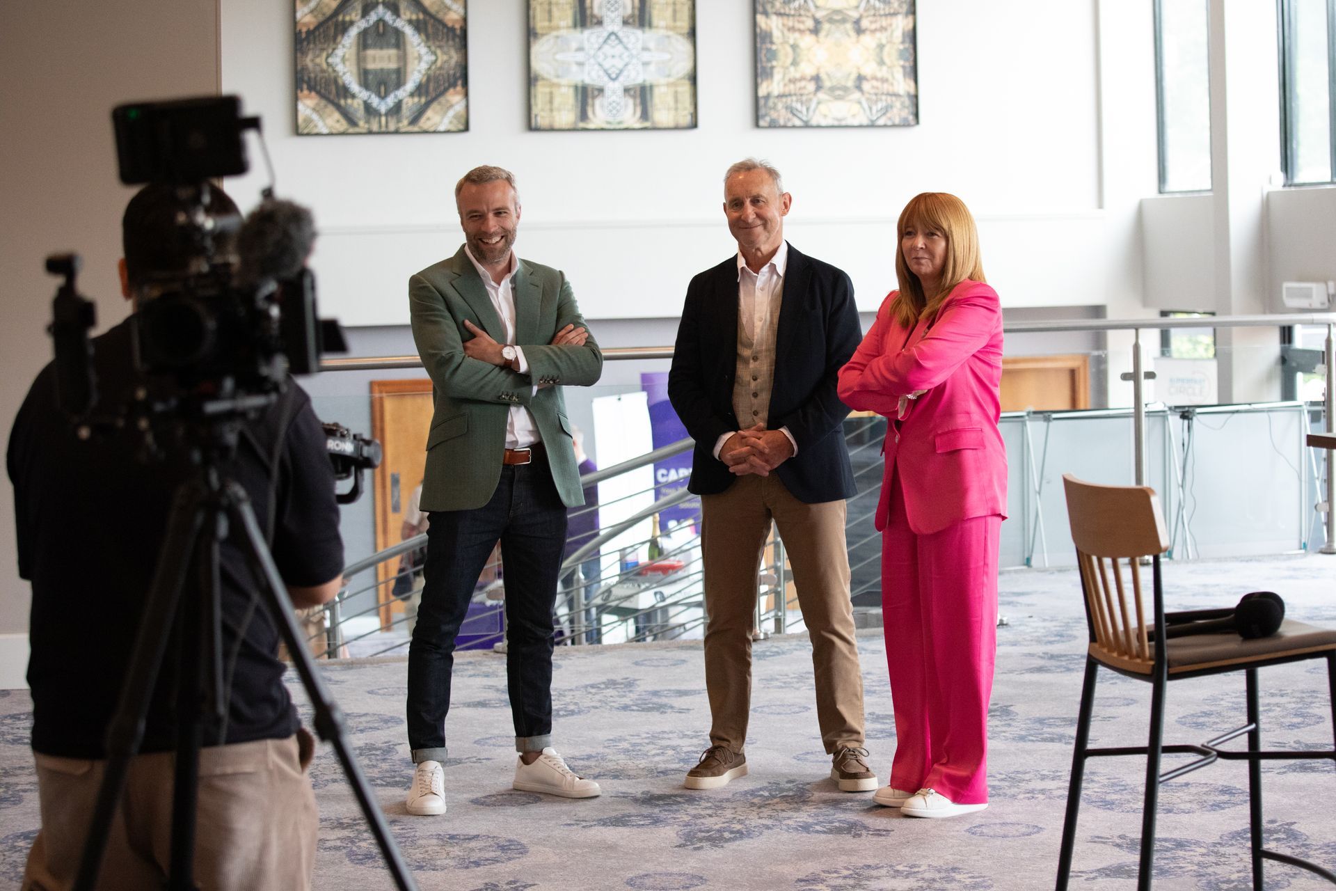 A group of people standing next to each other in front of a camera.