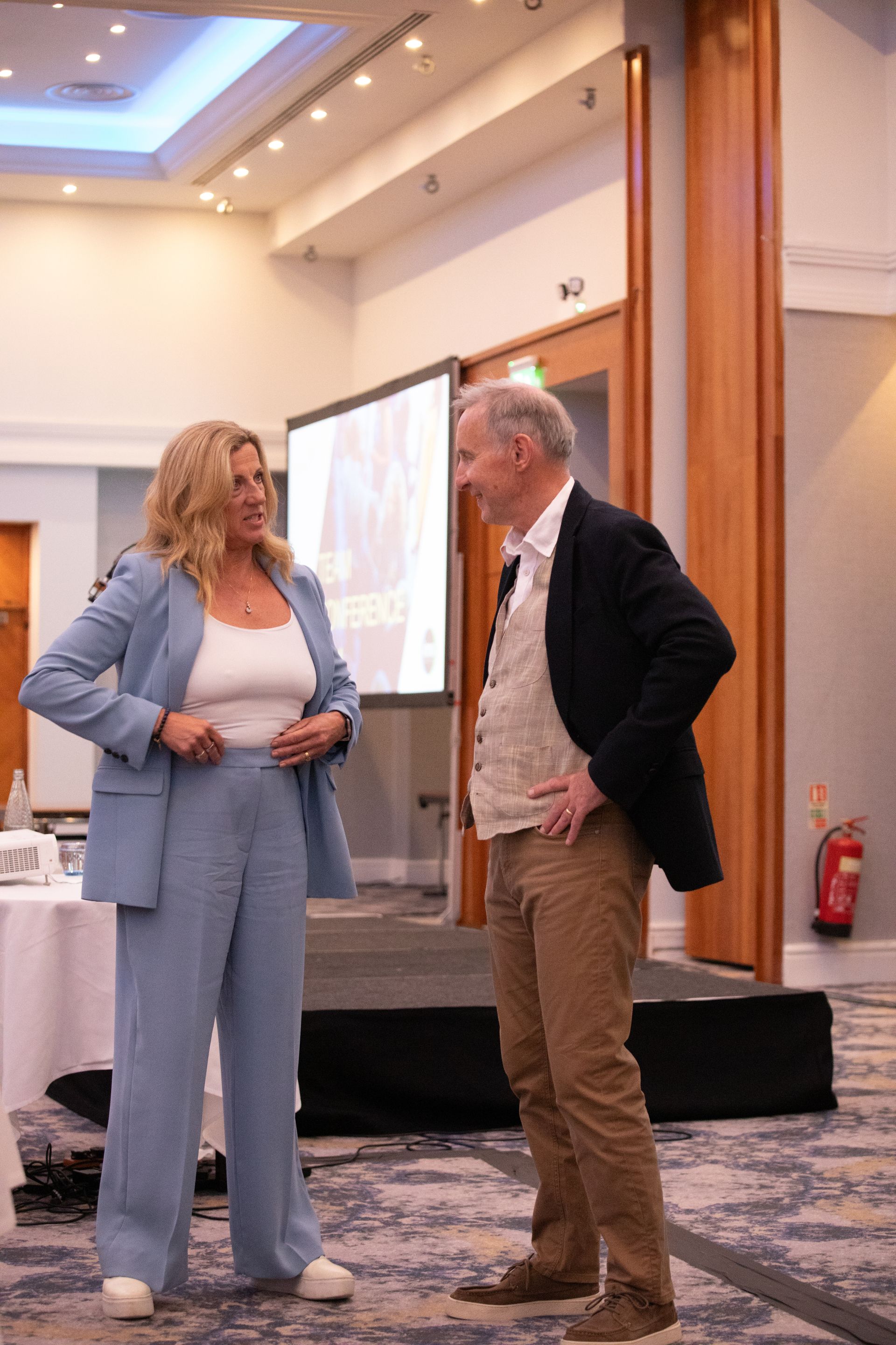 A man and a woman are standing next to each other in a room.